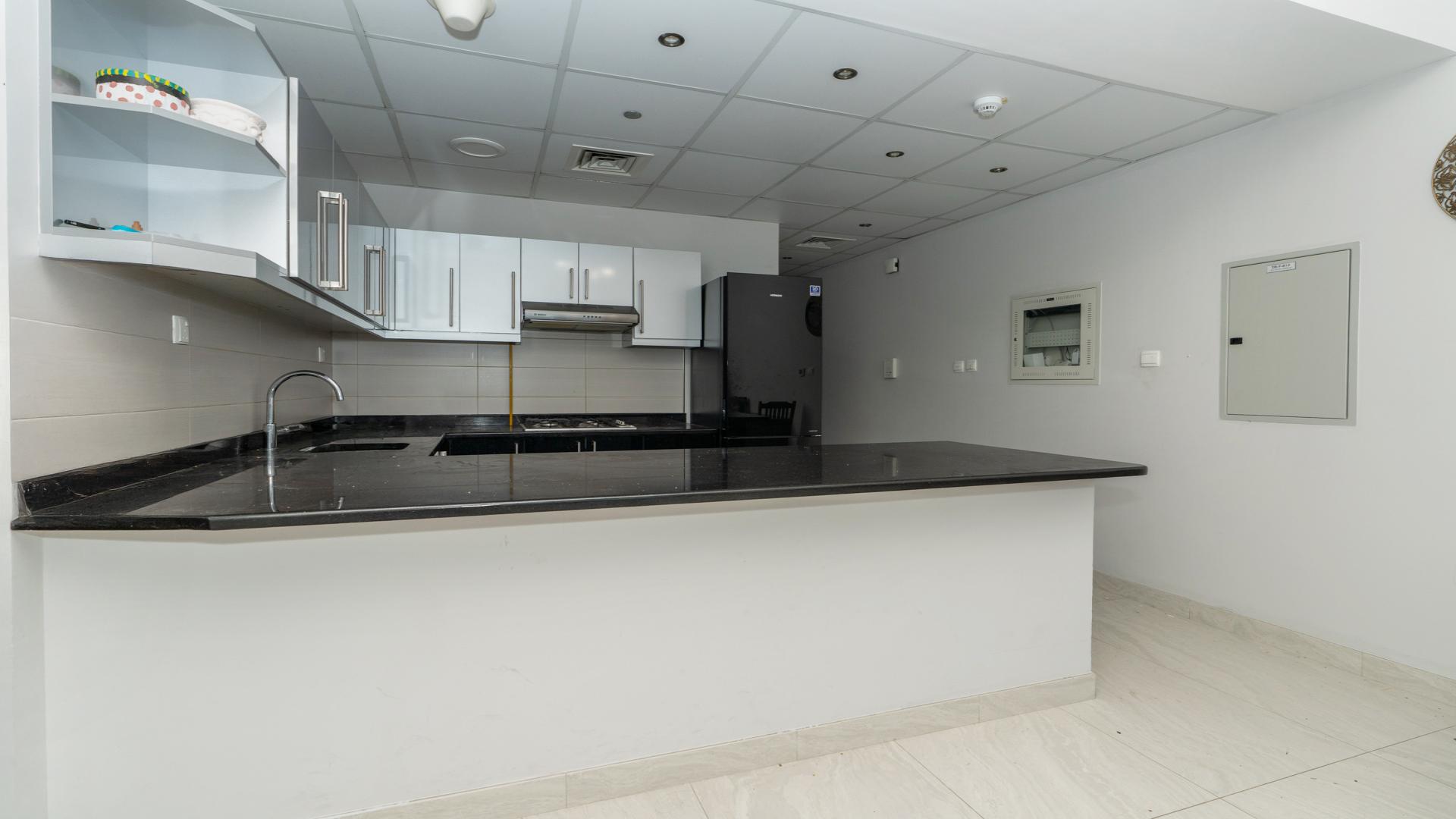"Spacious furnished kitchen and dining area in Business Bay apartment for sale, LP48650.",Modern kitchen in fully furnished apartment, Elite Business Bay, ideal for rental income