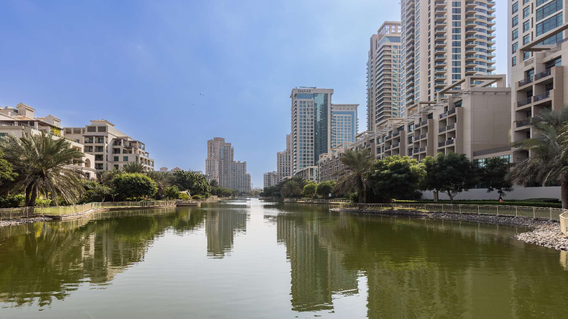 Outdoor dining area near Al Alka apartment for sale, featuring modern seating and umbrellas