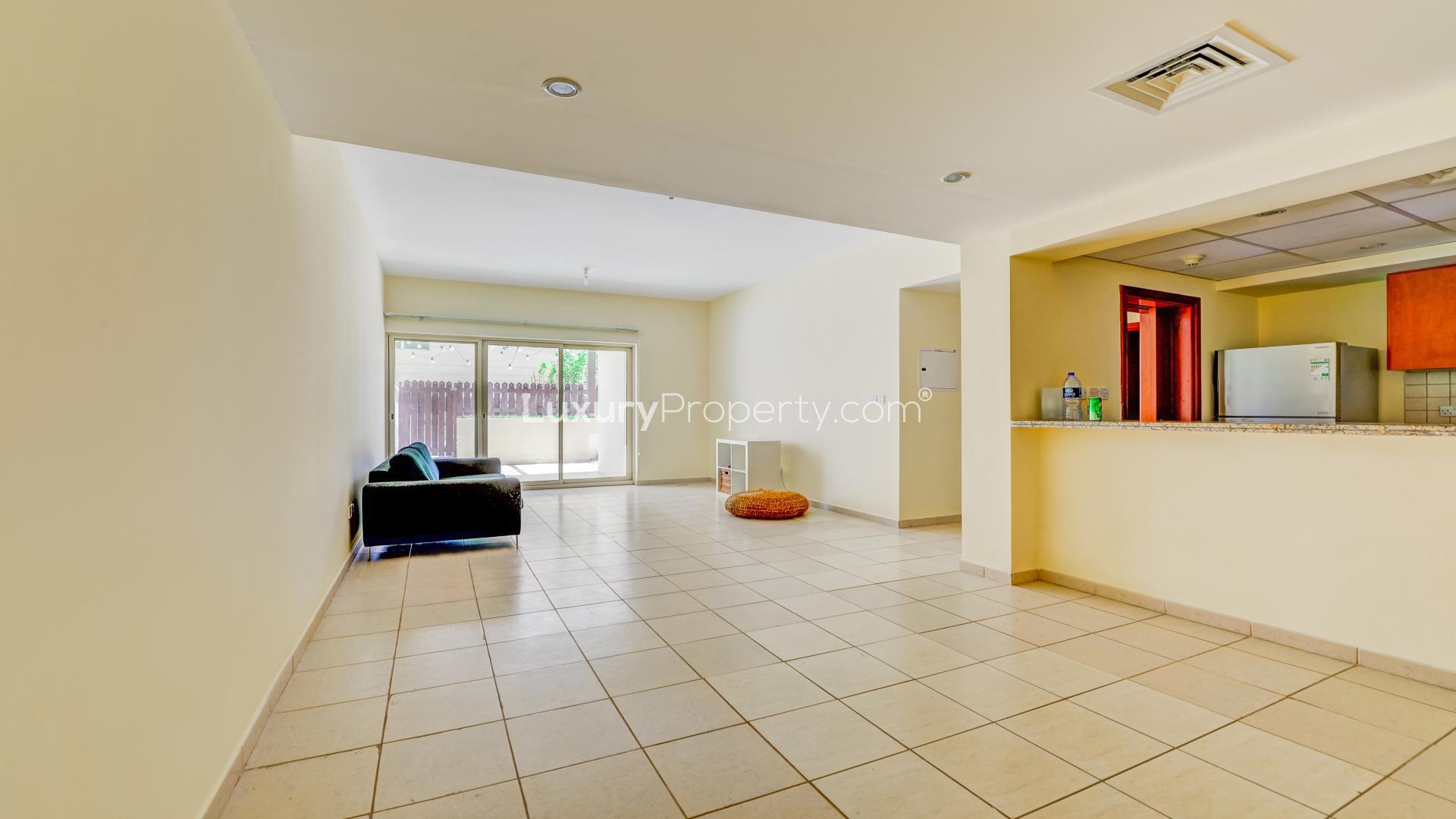 Spacious living room in Al Arta apartment with large windows and private courtyard access