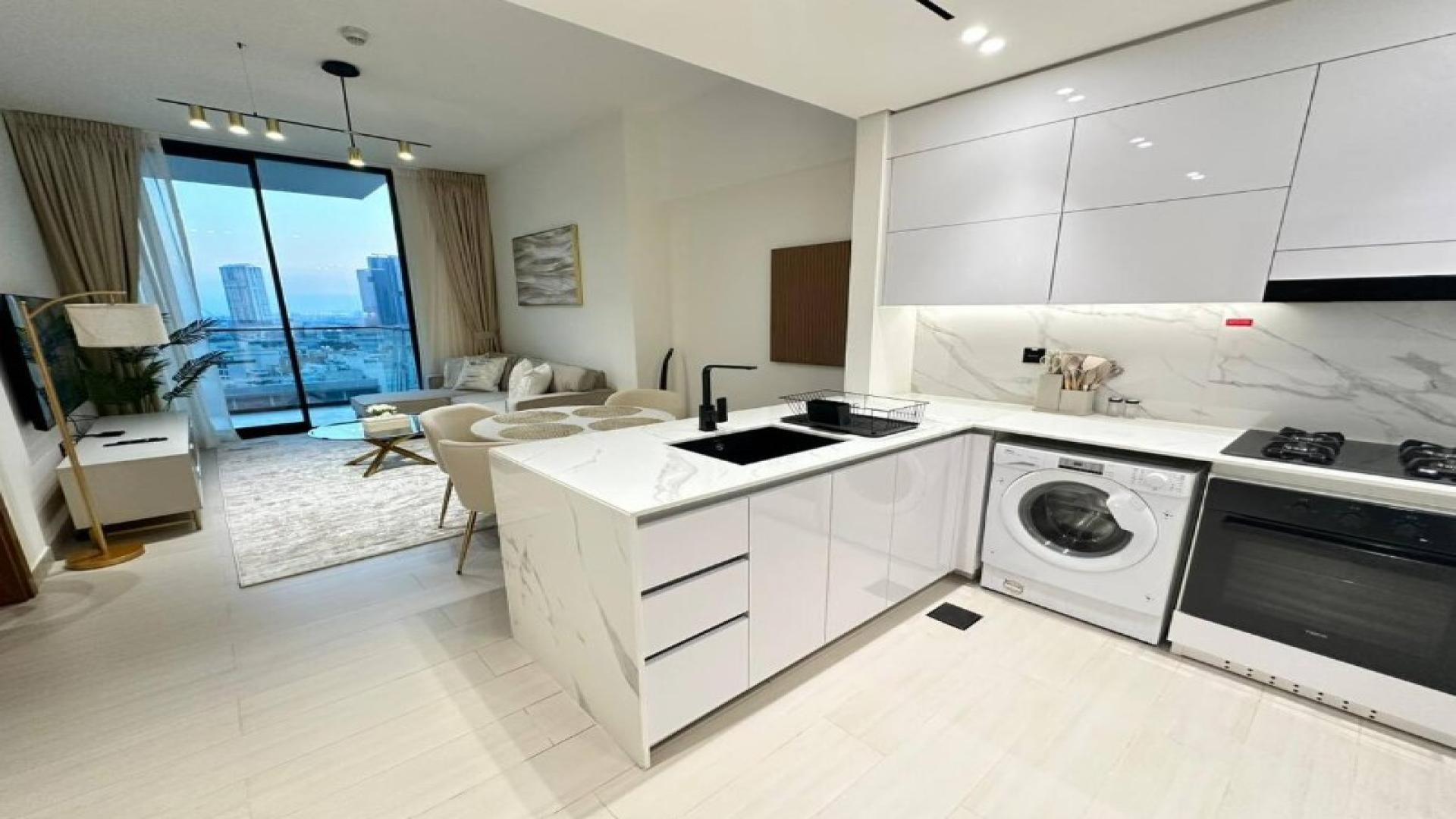 Modern living area in Jumeirah Village Circle apartment, featuring stylish decor and open kitchen
