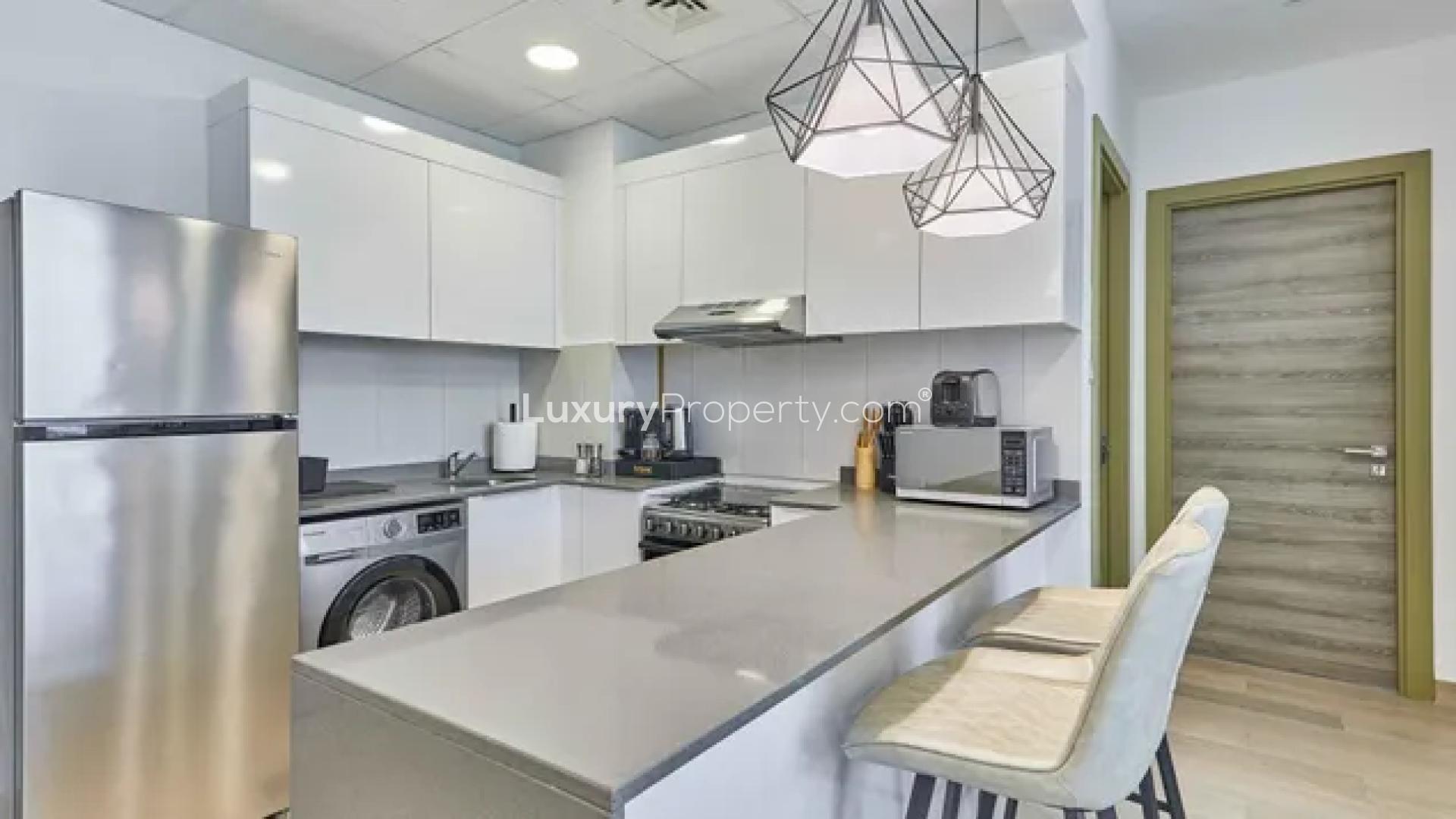 Modern kitchen in Bloom Heights apartment, Jumeirah Village Circle, featuring sleek white cabinetry