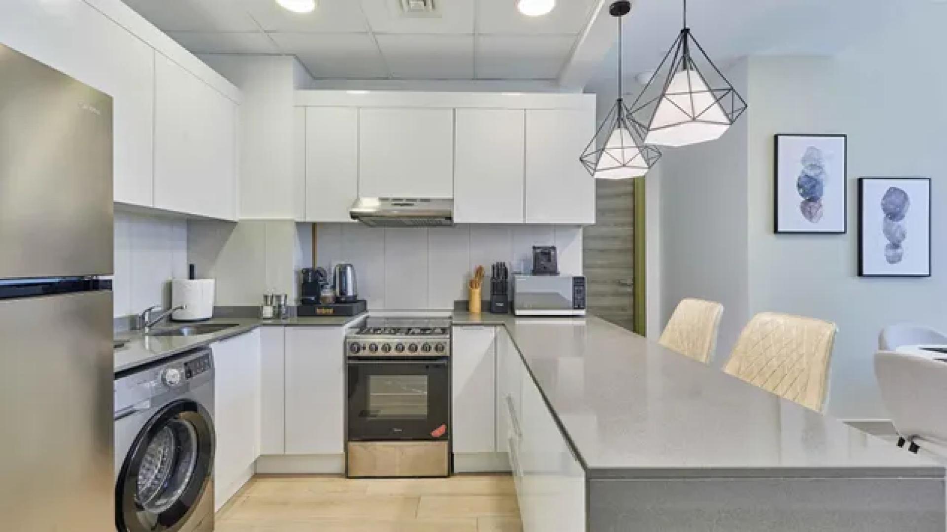 Modern dining area and kitchen in Bloom Heights apartment, Jumeirah Village Circle