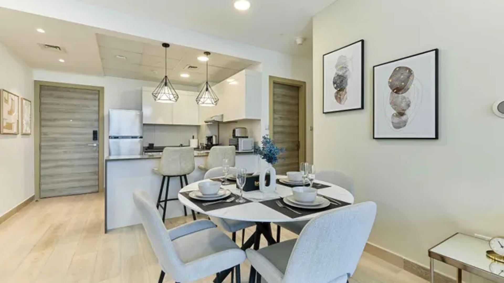Modern living room in Bloom Heights apartment, JVC, with dining area and balcony view
