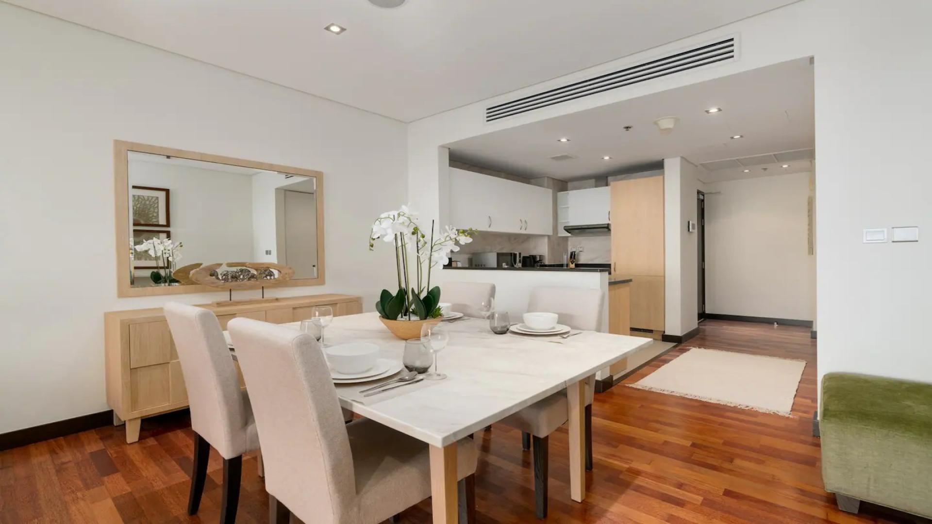 Furnished dining area in Palm Jumeirah apartment, featuring elegant decor and modern kitchen