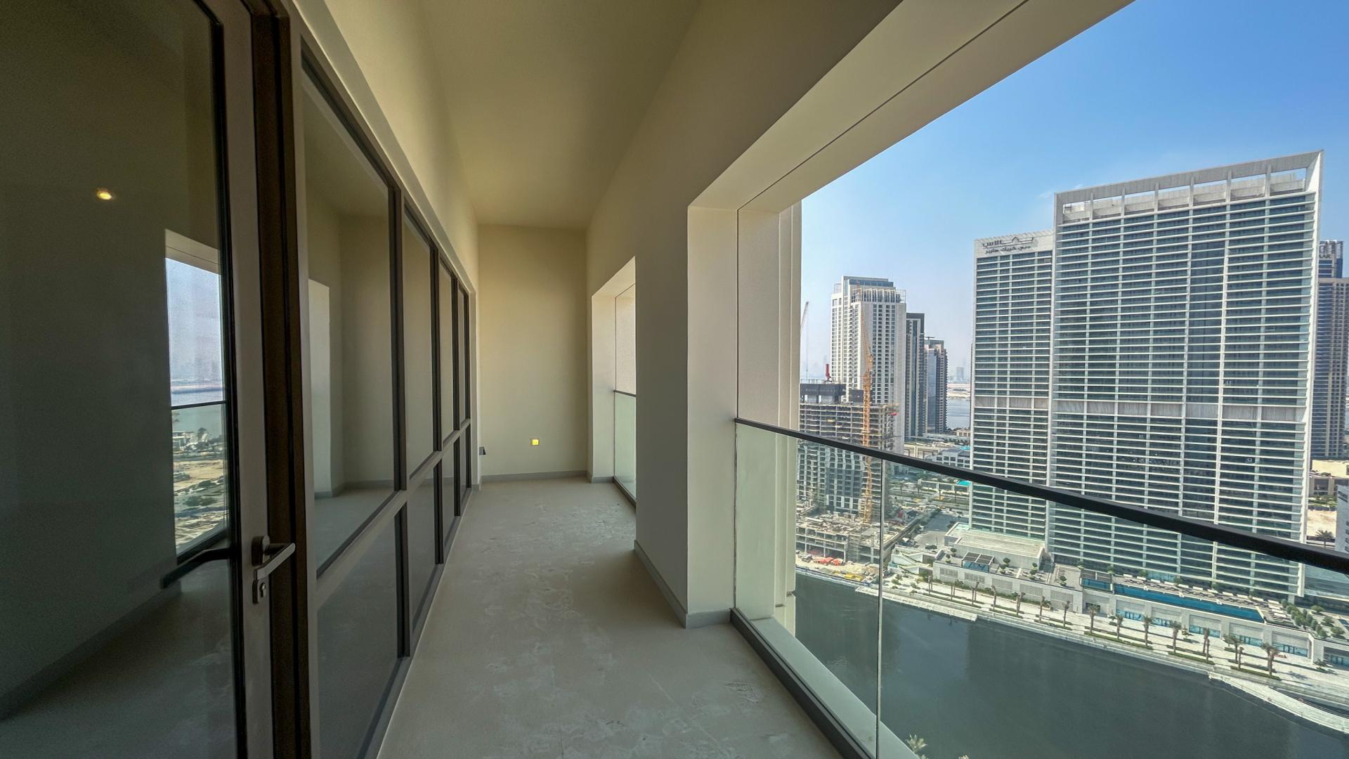 Empty living room with large window in Vida Residences, Dubai Creek Harbour apartment