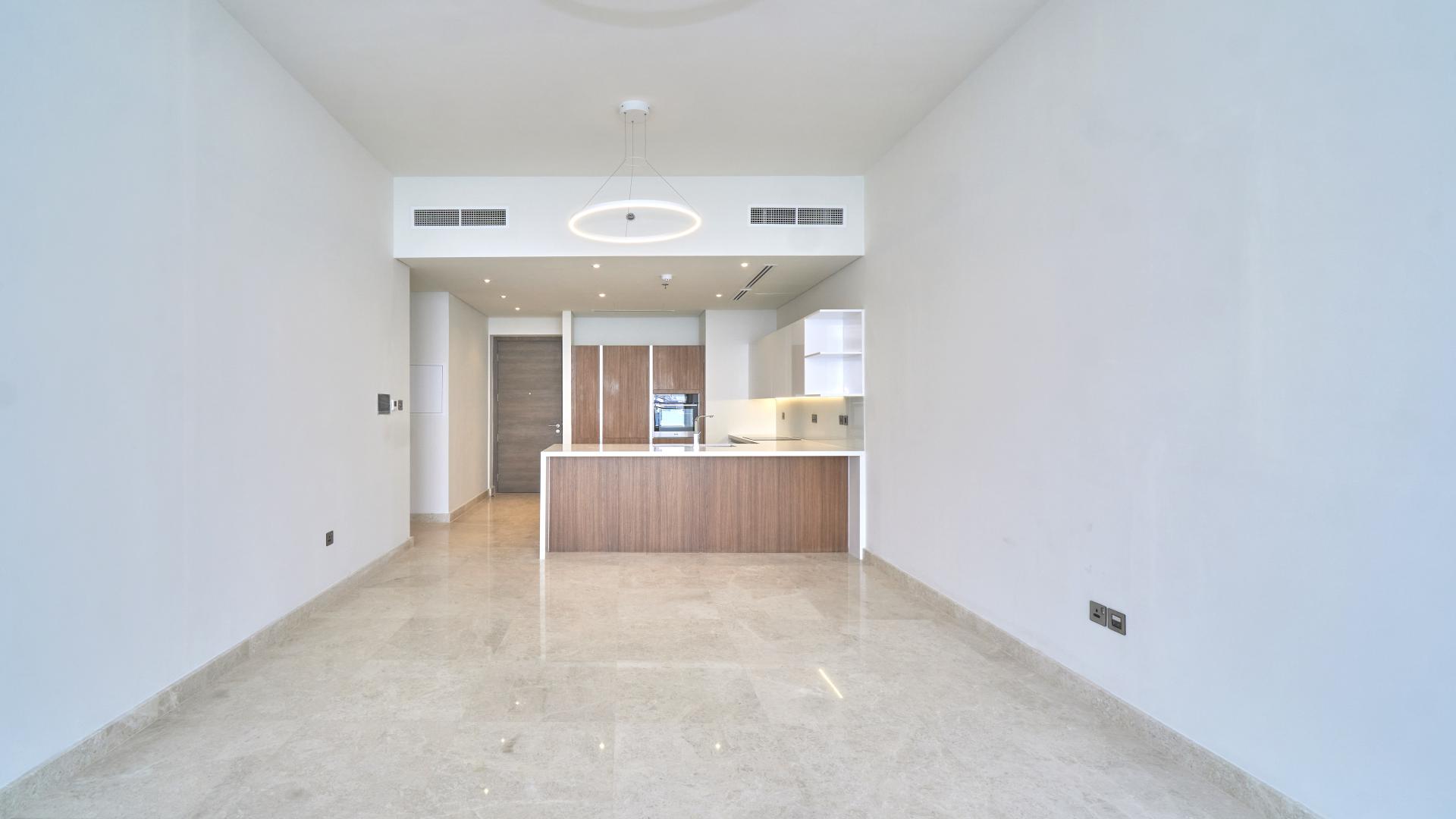 Modern kitchen in one-bedroom apartment, Anwa, Maritime City, featuring sleek countertops and wood cabinets