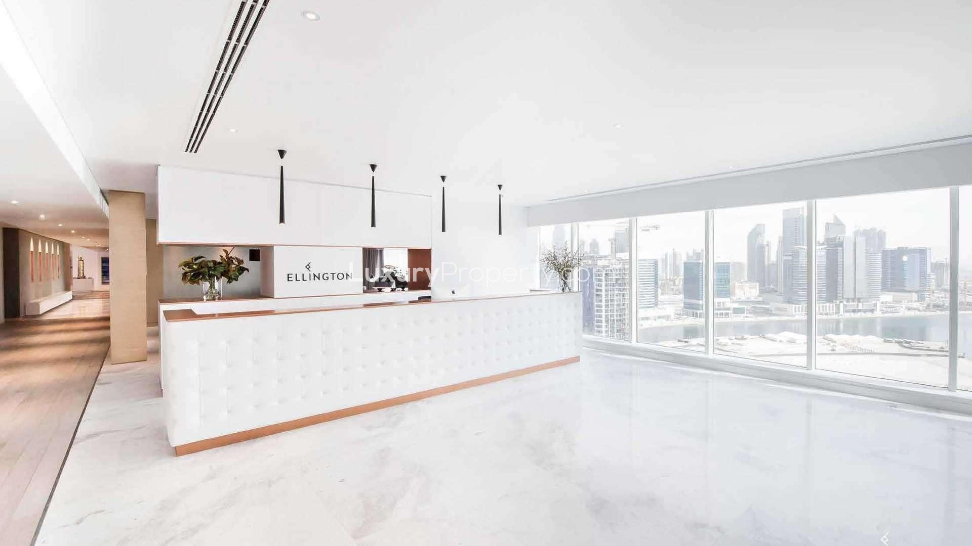 Modern living room in Belgravia 3 apartment, Jumeirah Village Circle, with large windows and seating