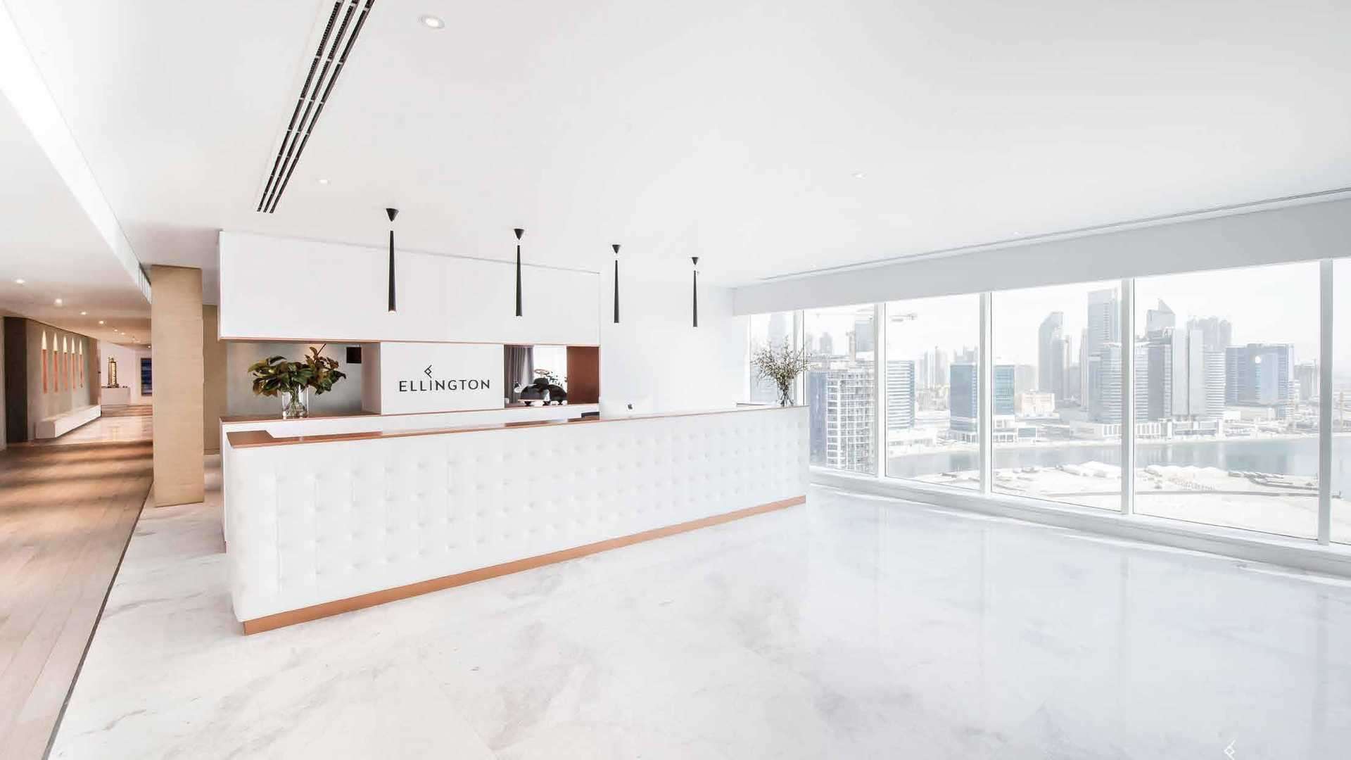 Modern living room in Belgravia 3 apartment, Jumeirah Village Circle, with large windows and seating