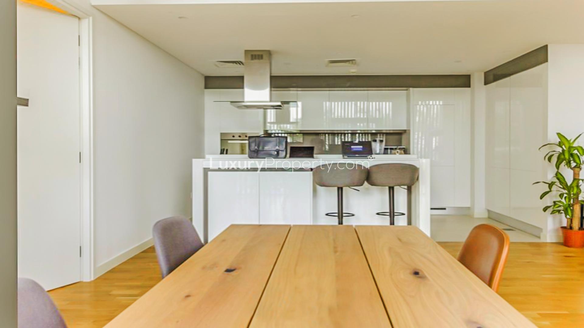 Fully furnished living room in Bluewaters apartment with modern decor and open kitchen