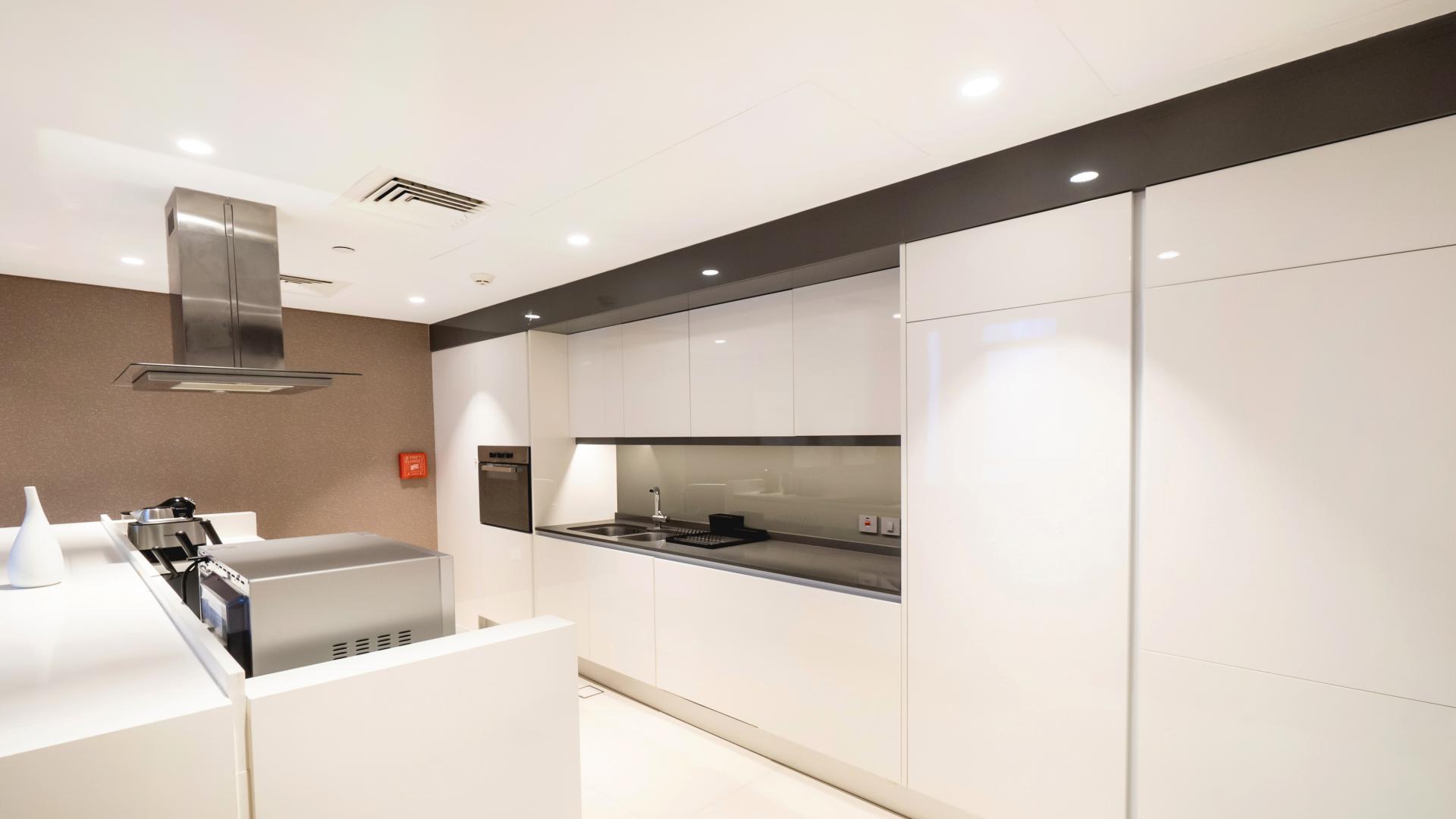 Modern kitchen in 1-bedroom apartment, Bluewaters Residences, featuring sleek cabinetry and appliances