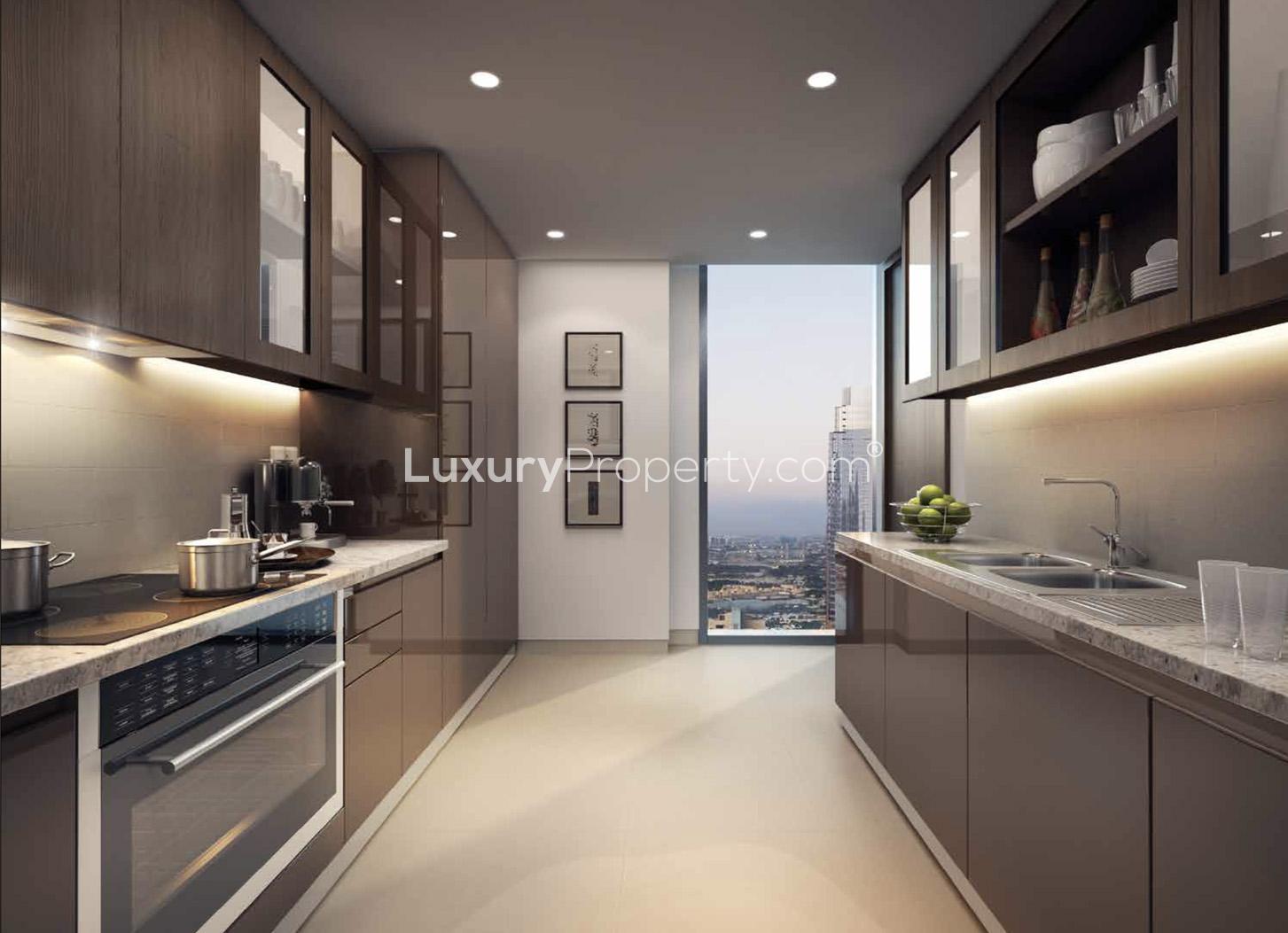 "Modern Boulevard Heights exterior view, Downtown Dubai, with palm trees and evening lights.",Modern kitchen in one-bedroom apartment at Boulevard Heights, Downtown Dubai, with city view