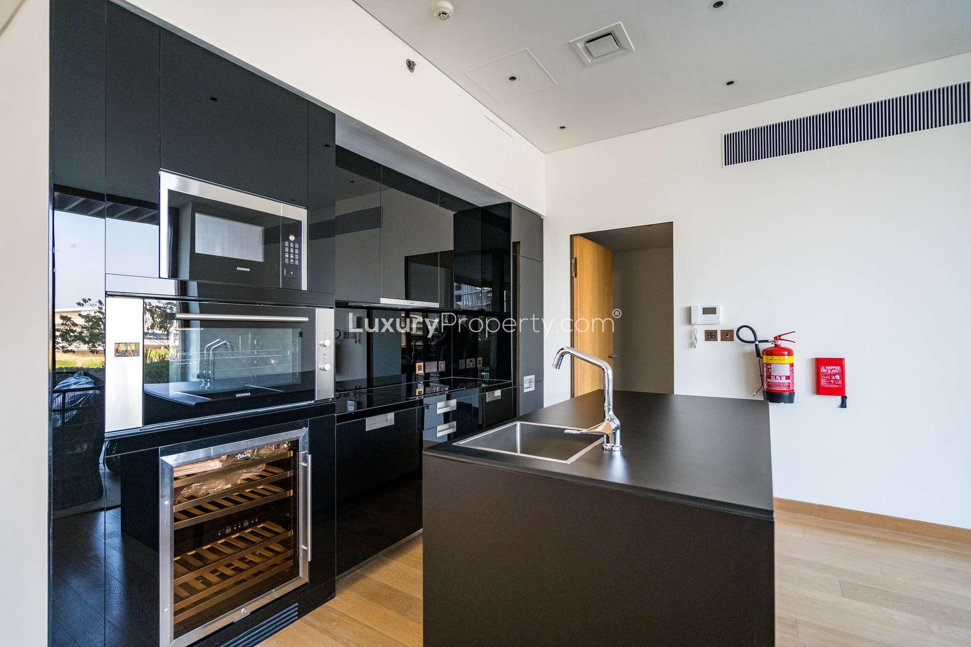Bright living area with wooden floors and large windows at Bulgari Residences, Jumeirah Bay