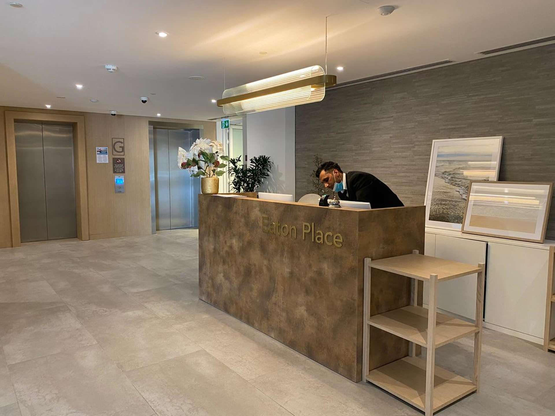 Lobby of Eaton Place, Jumeirah Village Circle apartment building with reception desk and elevators