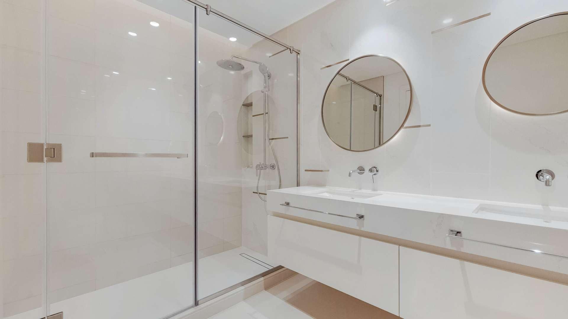 Modern bathroom with double sink and glass shower in Emaar Beachfront apartment, Dubai Harbour