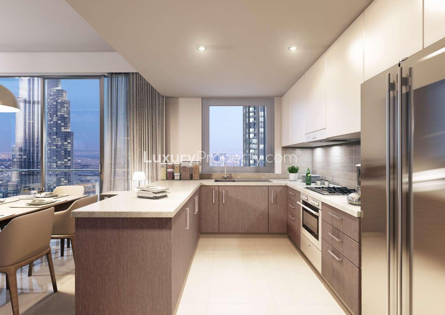 Alt text: "Downtown Dubai skyline view from Forte apartment, featuring iconic skyscrapers at twilight.",Modern kitchen in one-bedroom Downtown Dubai apartment, featuring sleek design and city views