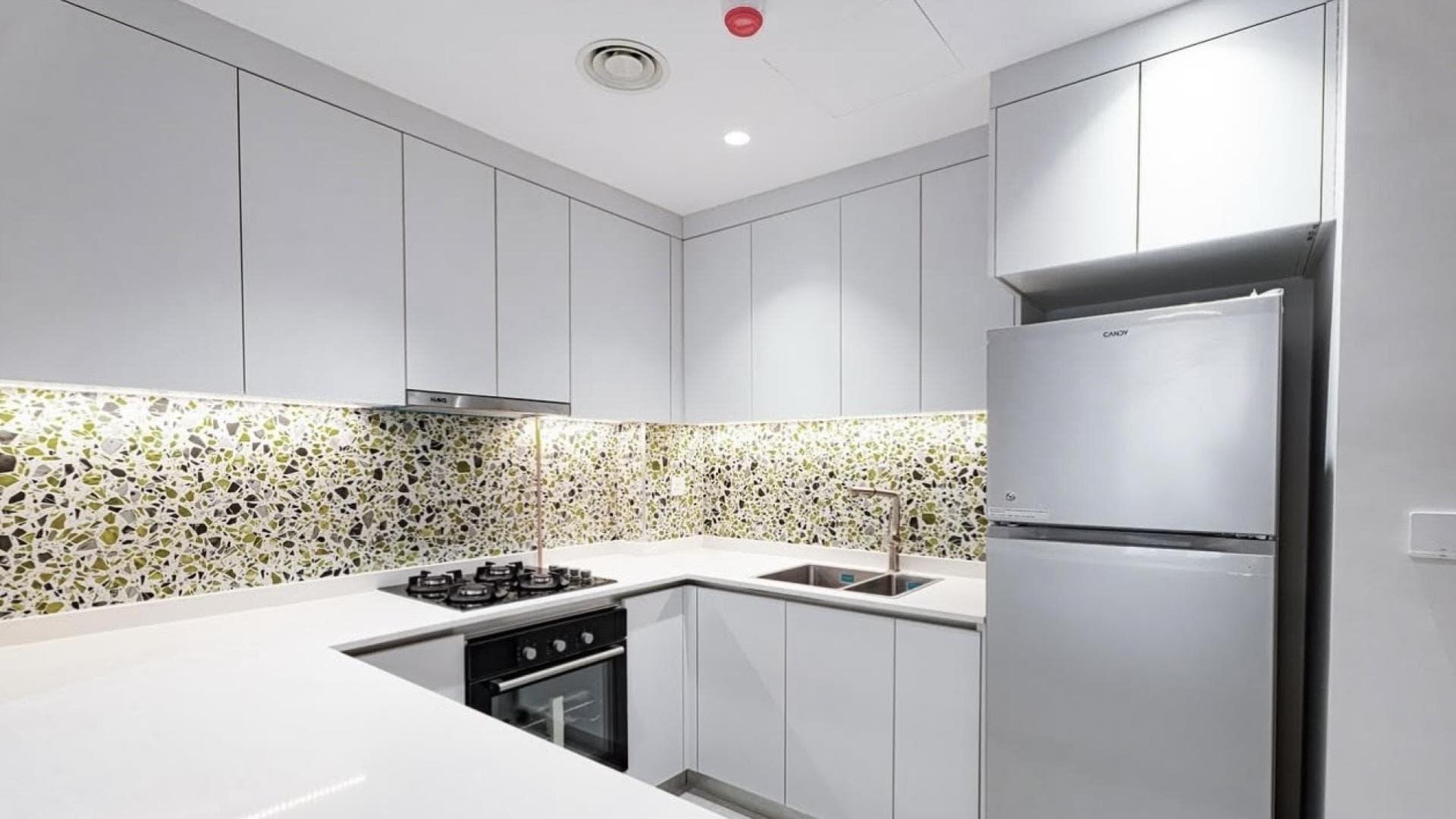 High-floor Neva Residences apartment living room, modern decor, large windows, Jumeirah Village Circle