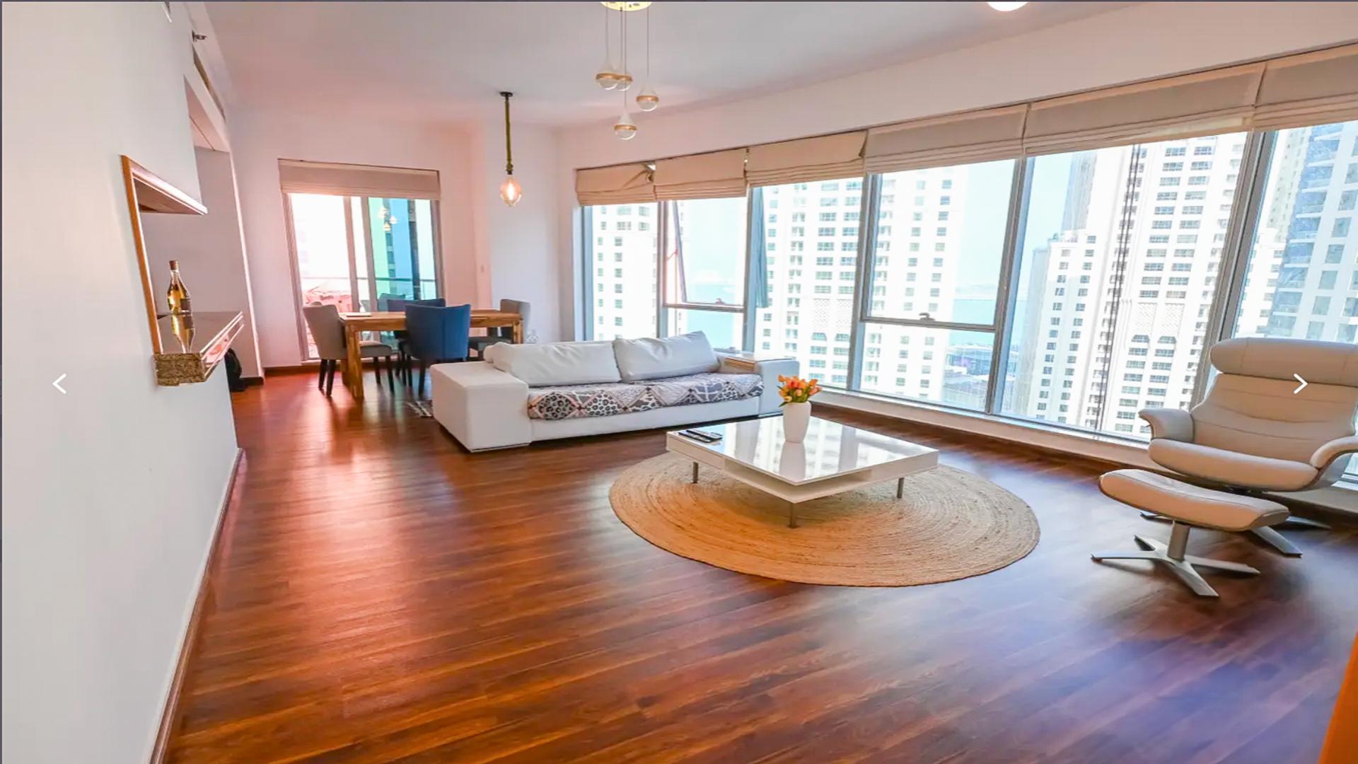 Dubai Marina promenade view with moored boats and waterfront skyscrapers, bright sunny day