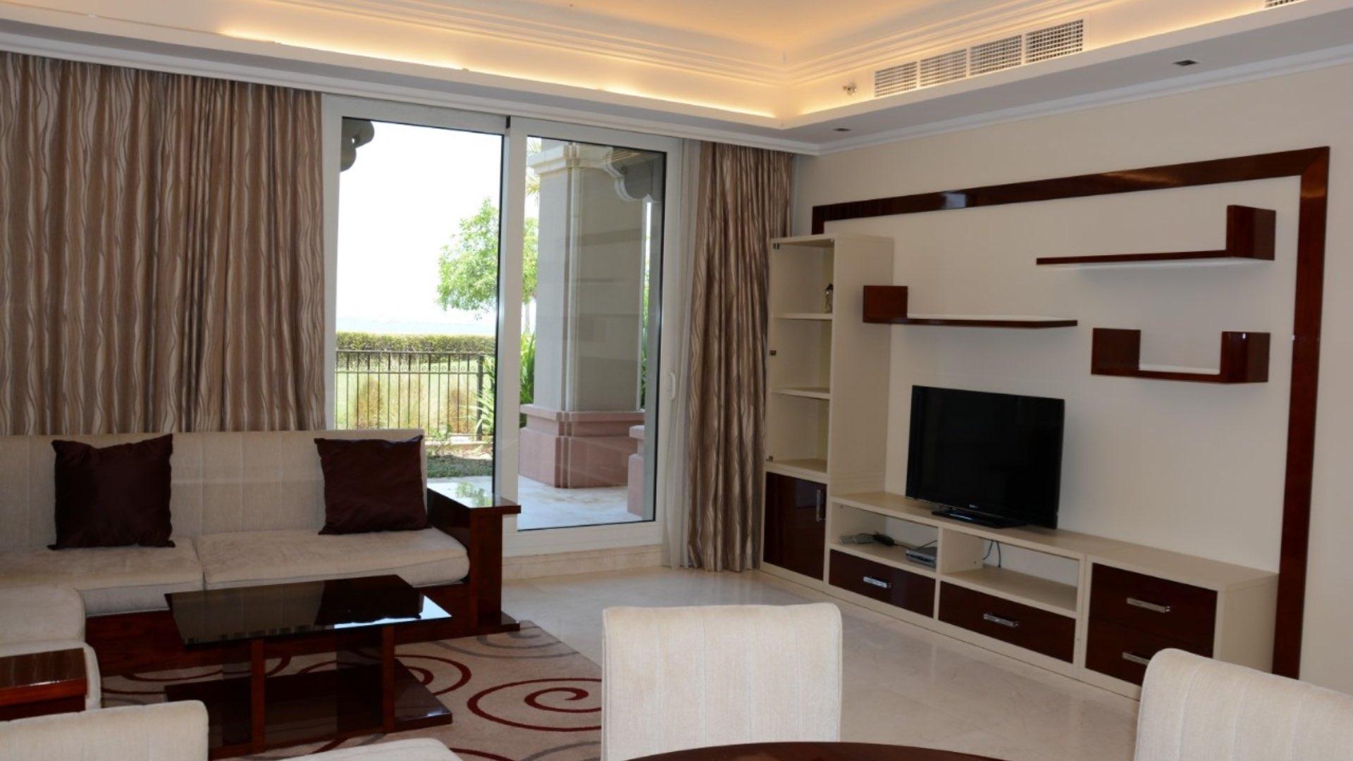 Outdoor pool area at Grandeur Residences, Palm Jumeirah, with palm trees and lounging chairs