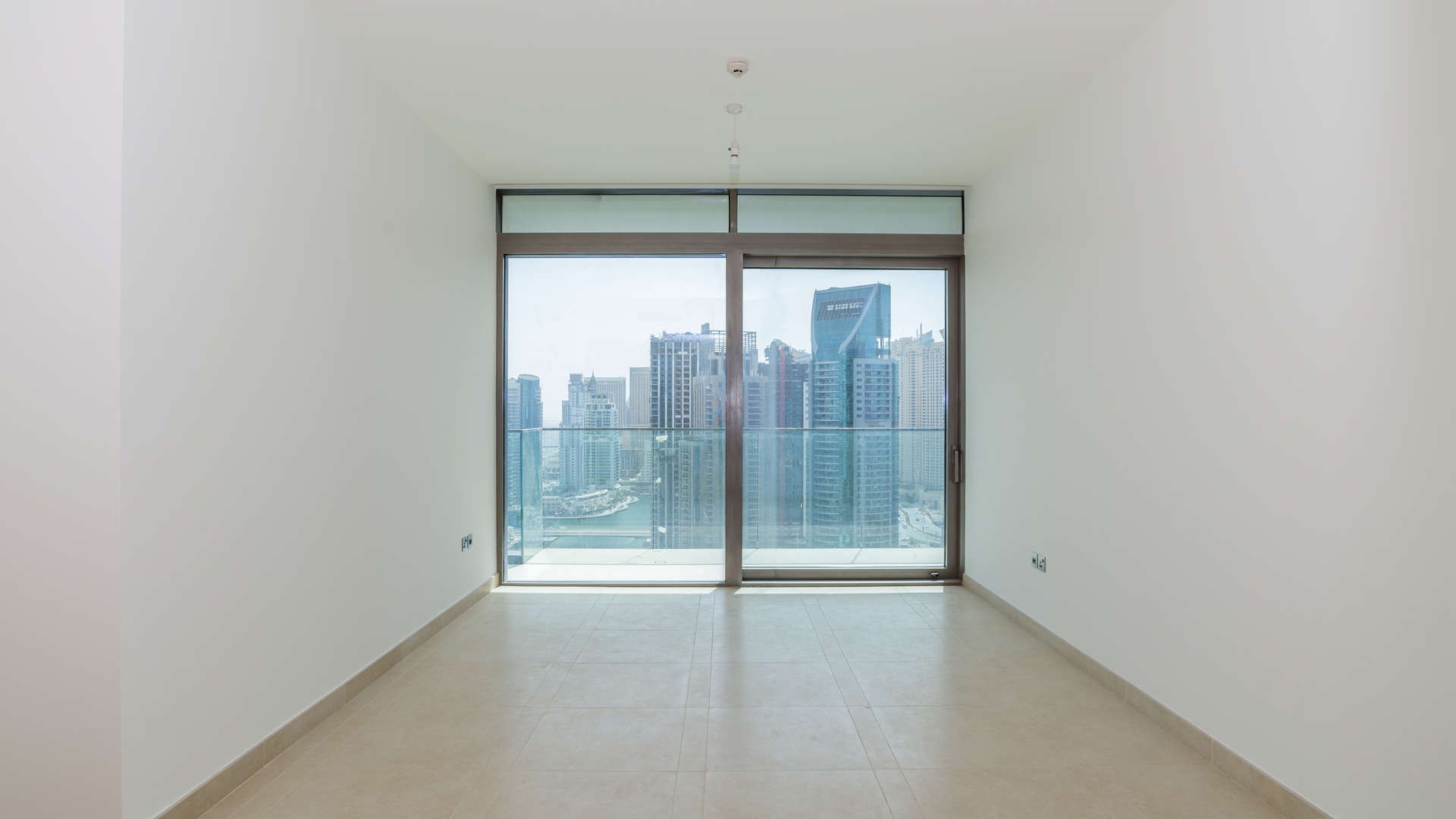 Empty bedroom with built-in wooden wardrobe at Jumeirah Living Marina Gate, Dubai Marina
