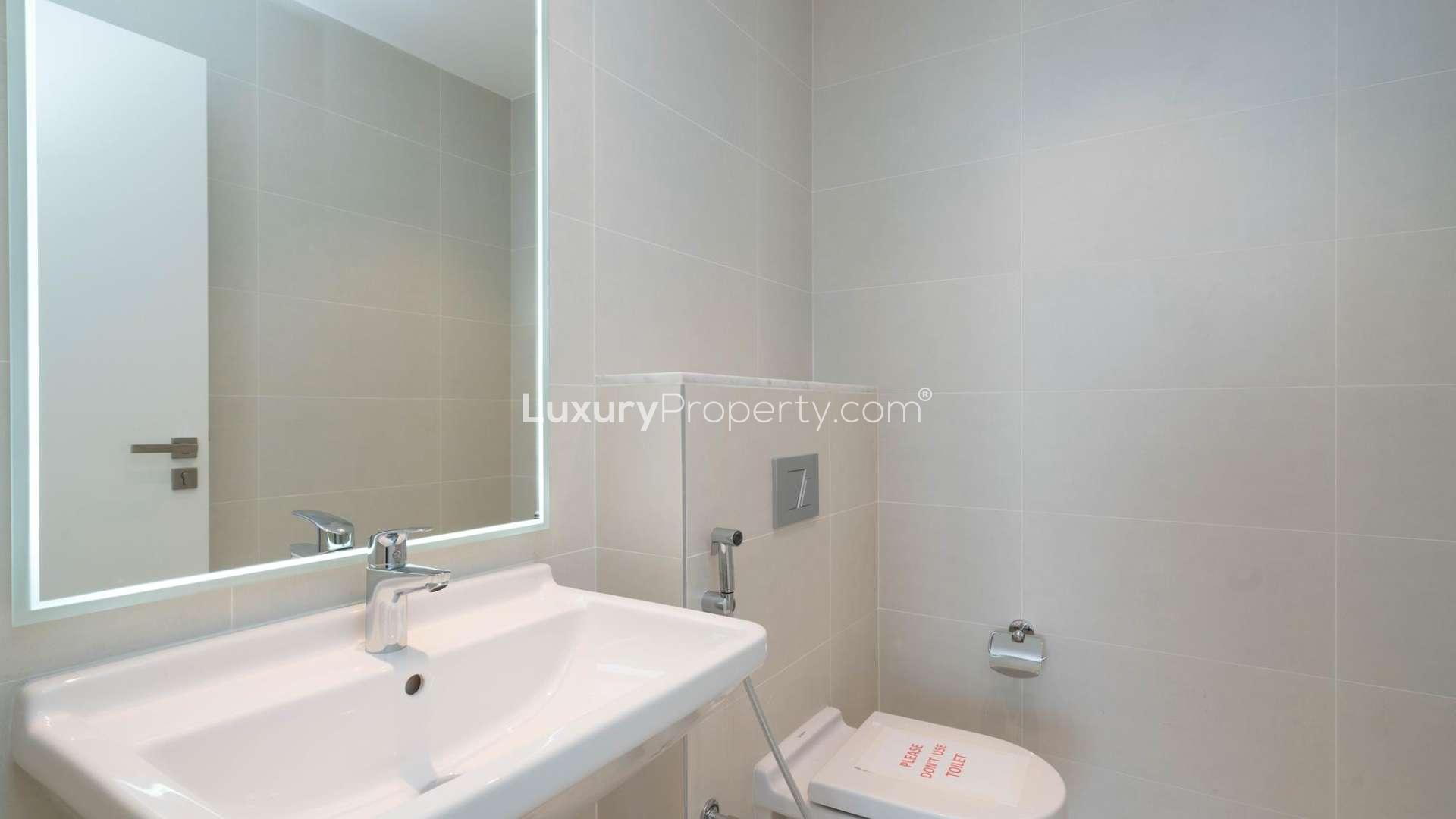 Empty room with wooden floor and large window in La Voile apartment, Jumeirah