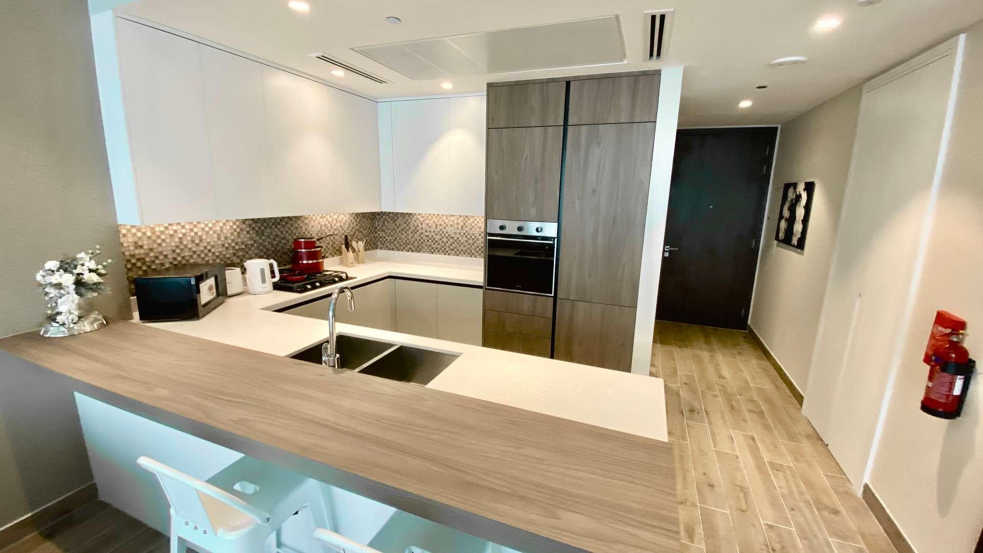 Modern living area with stylish furniture and kitchen in Marina Gate apartment, Dubai Marina