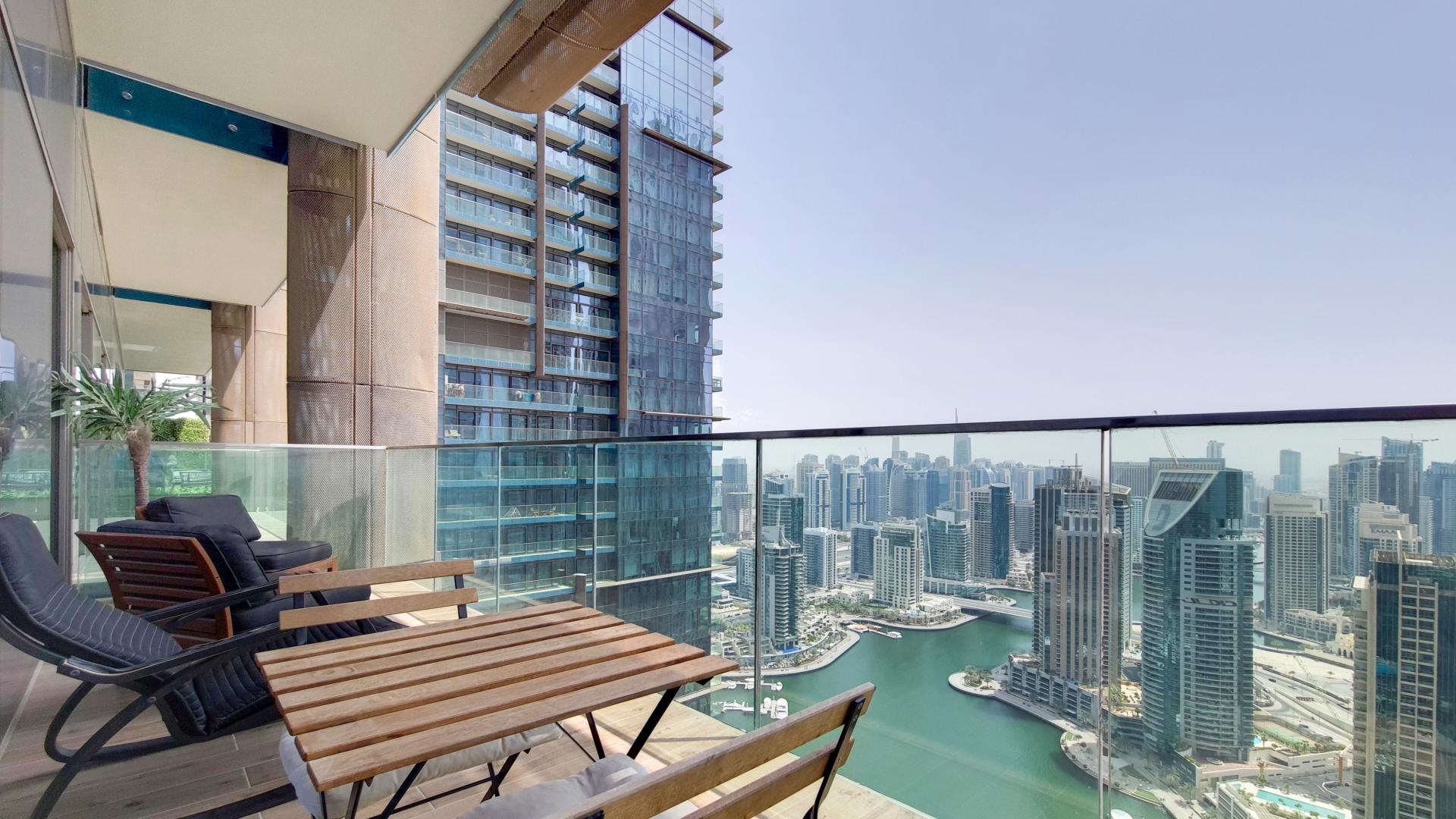 High-floor Dubai Marina apartment living room with modern decor and marina view balcony