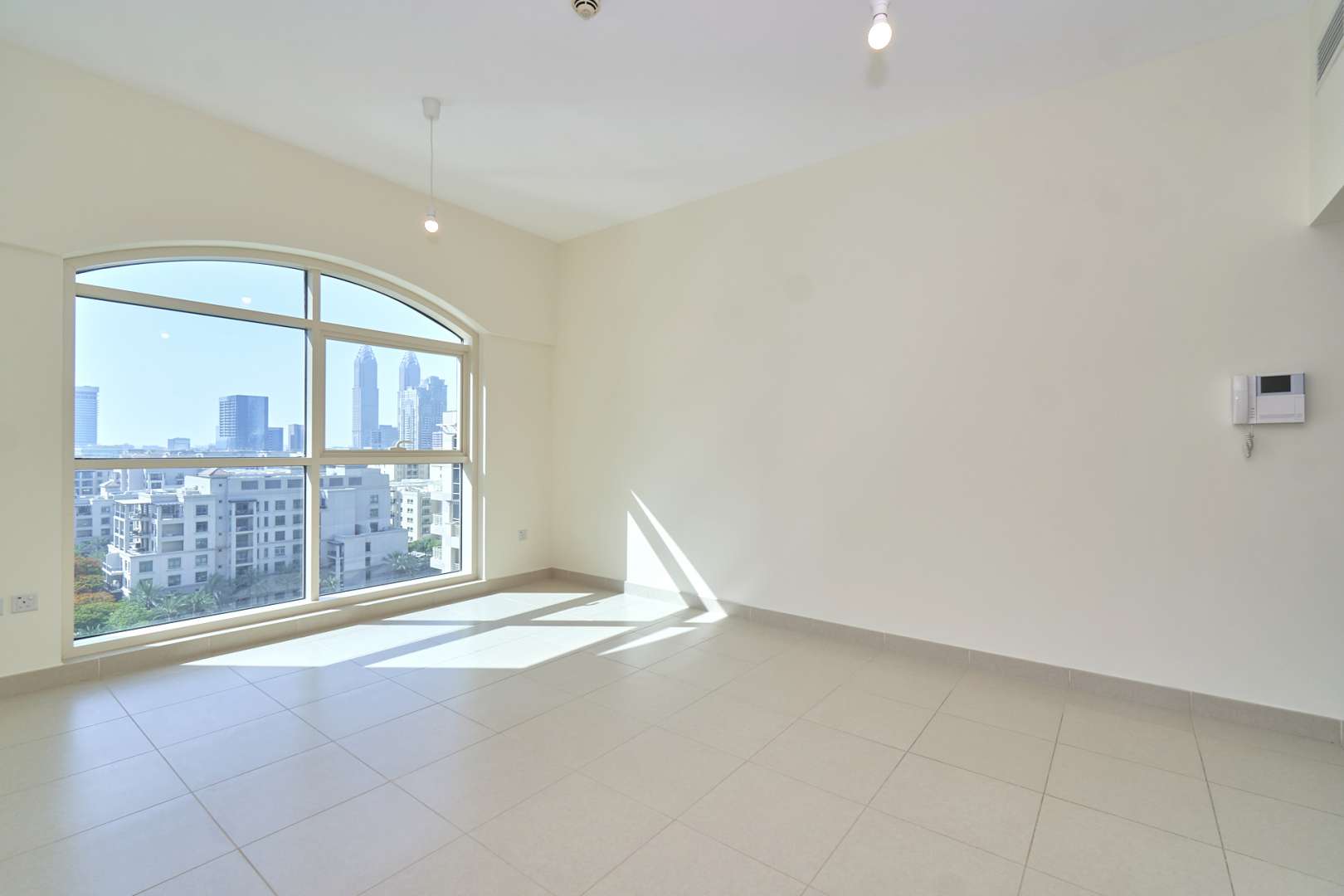 "Spacious balcony view from 1-bedroom apartment in Mosela Tower, The Views, Dubai.",Bright living room with large window, city views in 1-bedroom Mosela Tower apartment, Dubai