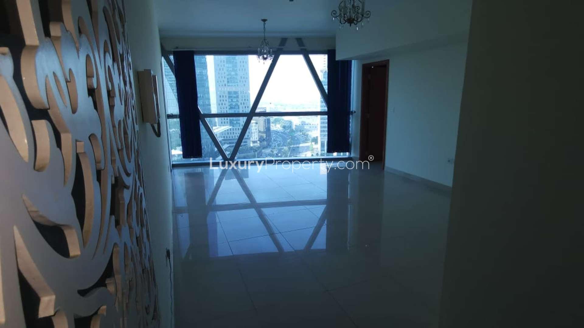 Bedroom with modern decor, large bed, and balcony view in Park Towers apartment, DIFC