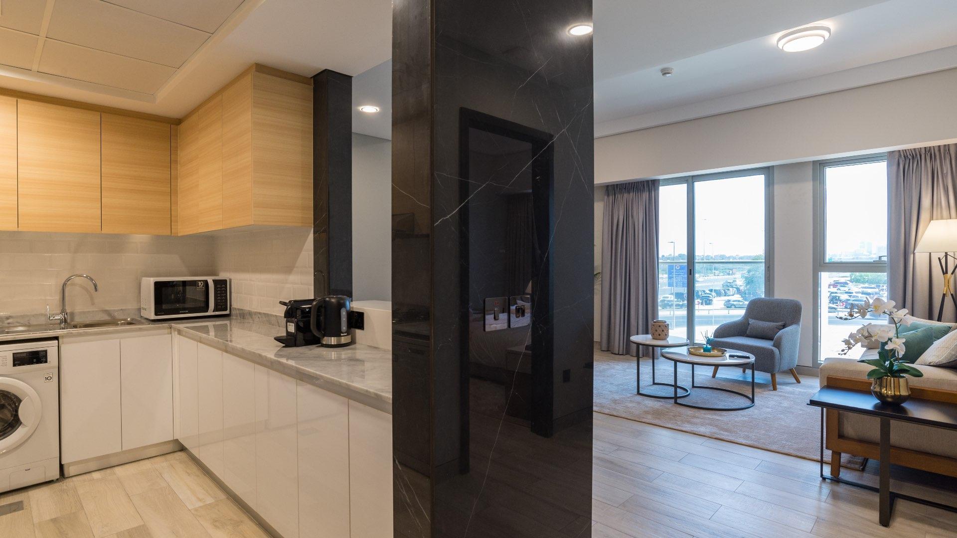 "Modern yellow facade of Priva Living apartment building in Arjan, available for rent.",Modern kitchen and living area in fully furnished 1-bedroom apartment, Priva Living, Arjan