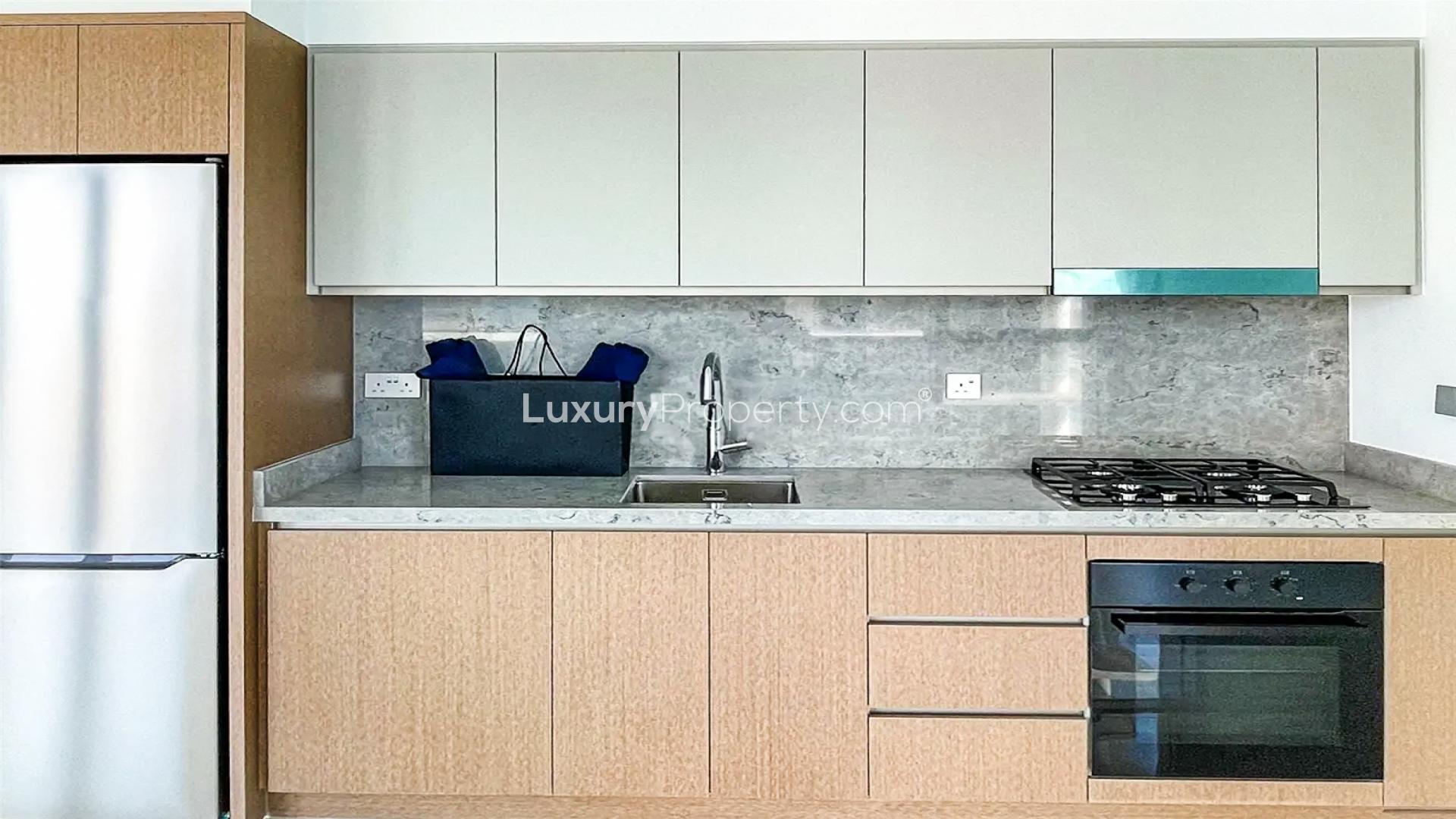 Modern kitchen in Dubai Harbour apartment with sleek cabinets and large windows