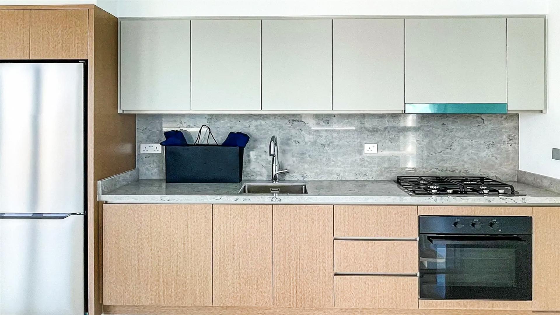 Modern kitchen in Dubai Harbour apartment with sleek cabinets and large windows