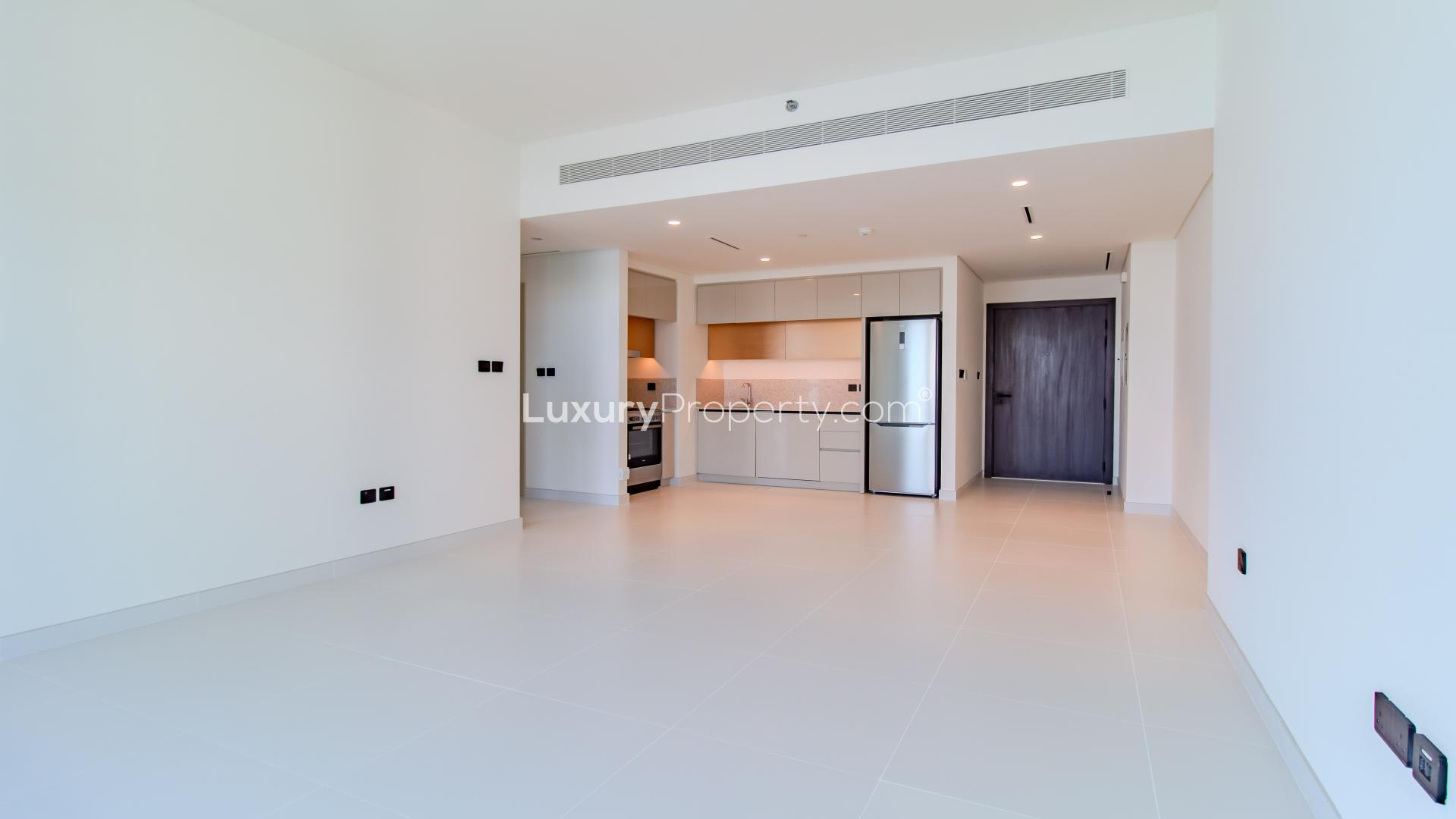 "Modern apartment exterior at Emaar Beachfront, Dubai Harbour with lush greenery and beachfront view.",Modern kitchen in one-bedroom apartment for sale, Marina Vista, Emaar Beachfront, Dubai Harbour