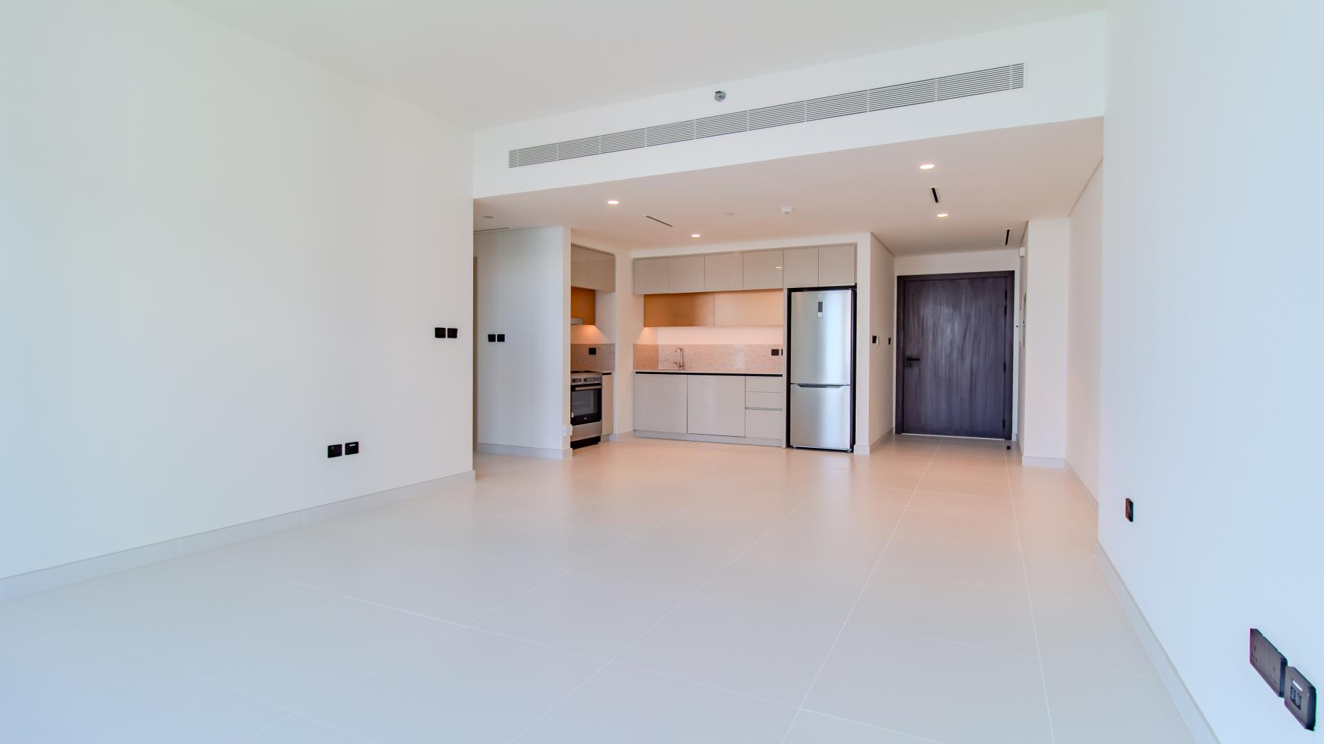 "Modern apartment exterior at Emaar Beachfront, Dubai Harbour with lush greenery and beachfront view.",Modern kitchen in one-bedroom apartment for sale, Marina Vista, Emaar Beachfront, Dubai Harbour