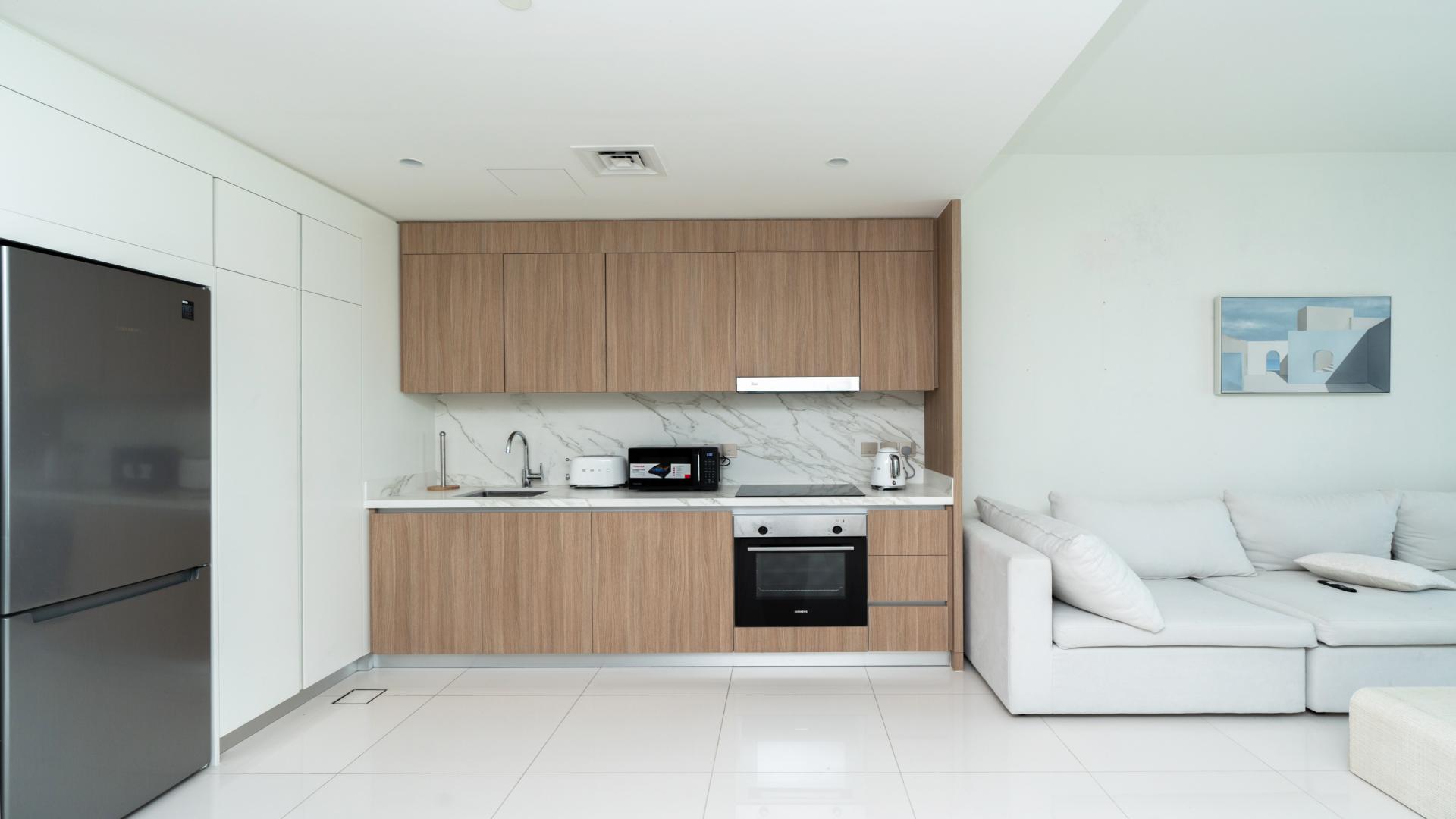 High-floor Dubai Harbour apartment living room with modern decor and kitchen area