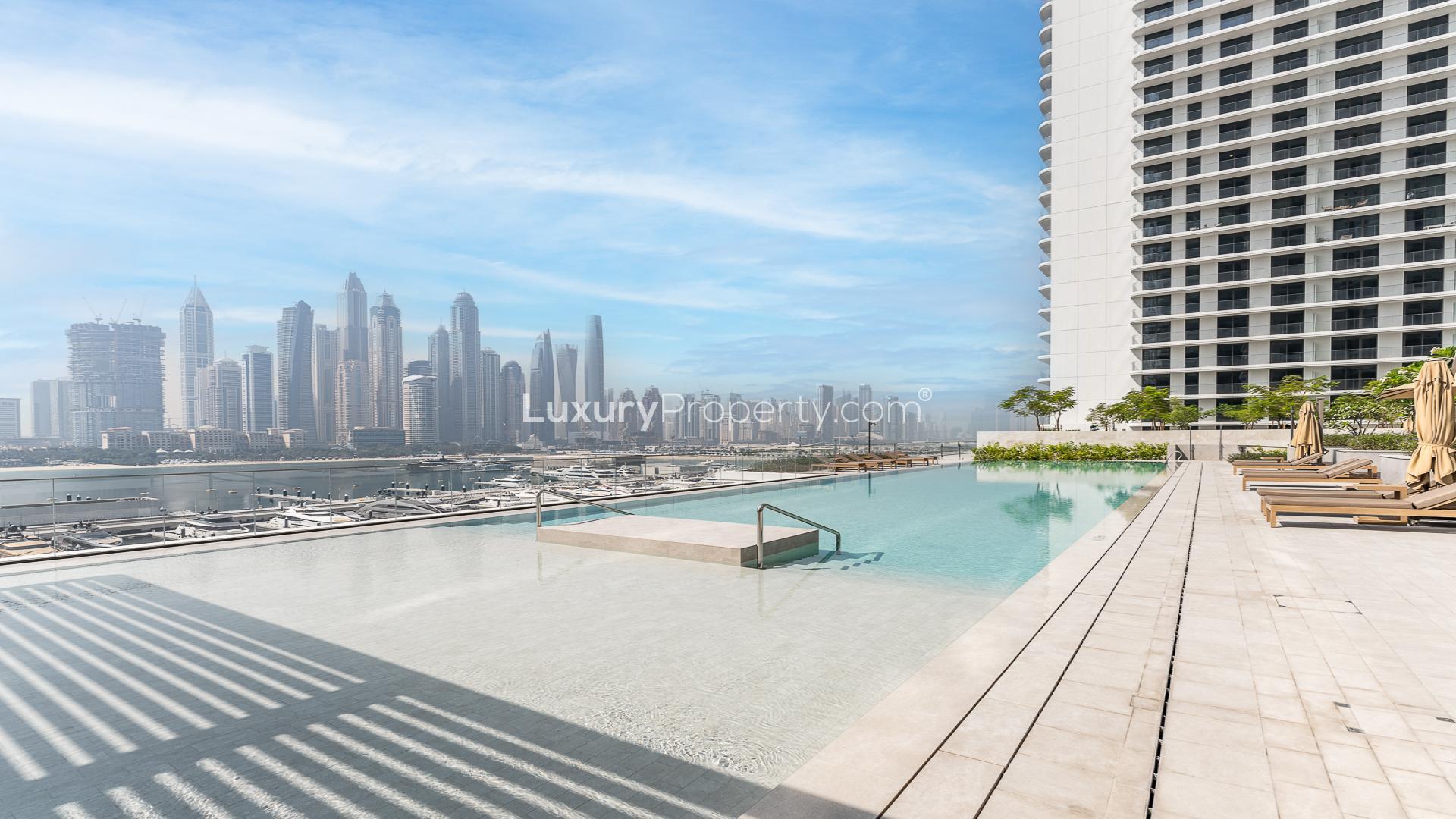 "Modern apartment exterior with pool at Emaar Beachfront, Dubai Harbour for sale.",Infinity pool with Dubai Marina skyline view at Emaar Beachfront, Palace Beach Residence apartment