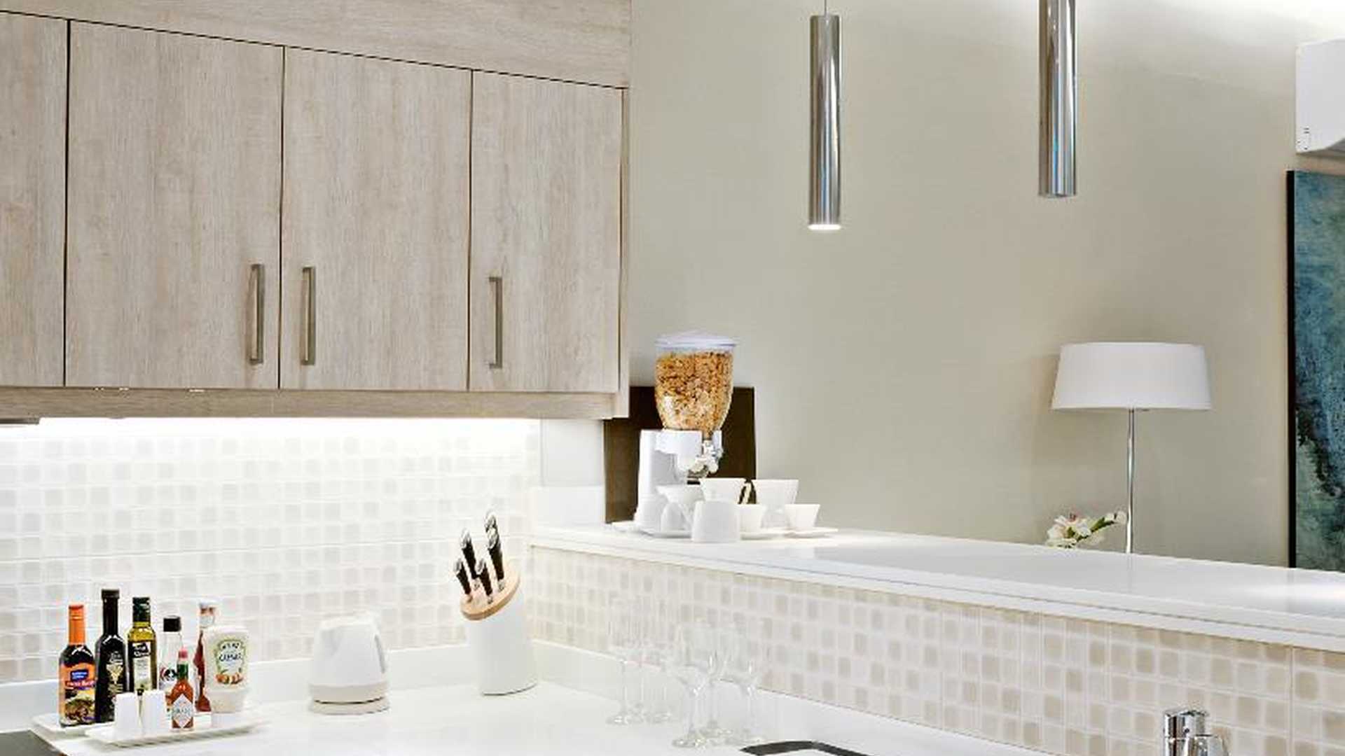 Contemporary living room in Jumeirah Lake Towers apartment with modern decor and kitchen view