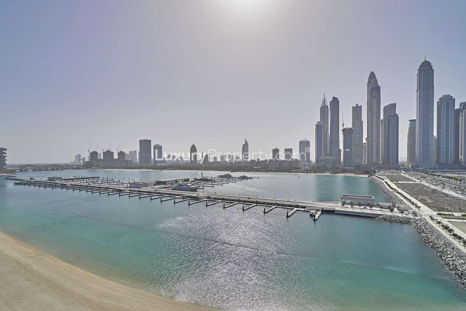 Furnished bedroom in Emaar Beachfront apartment, Dubai Harbour, with modern decor and en-suite bathroom