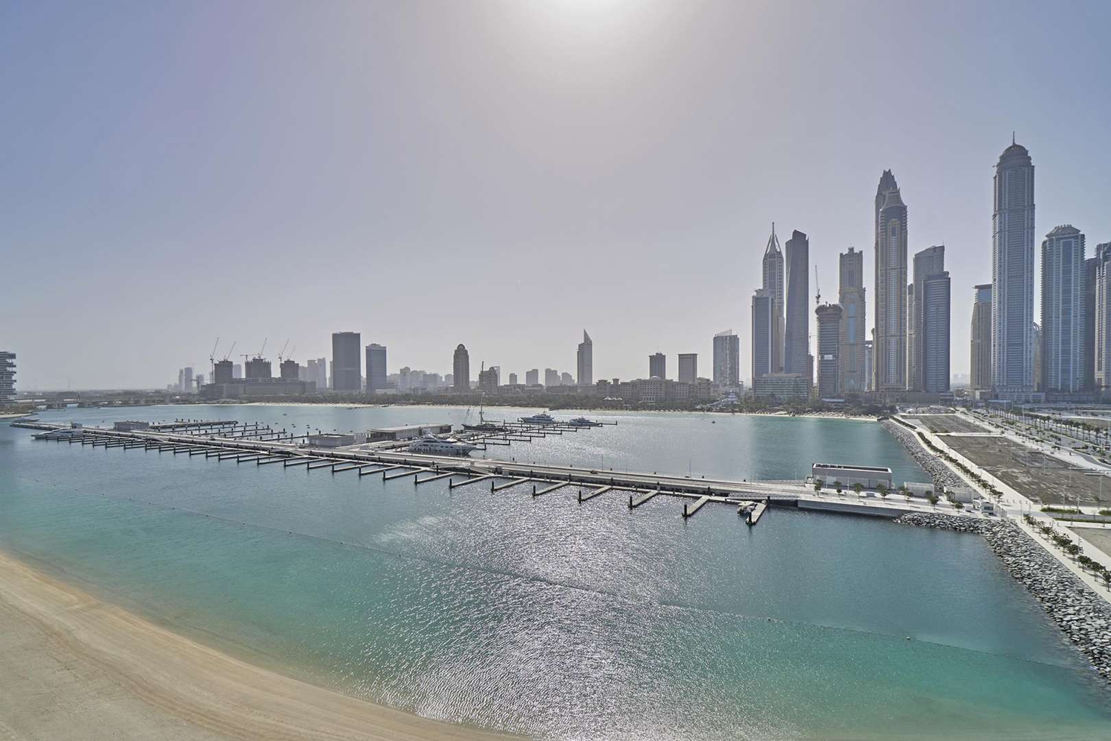 Furnished bedroom in Emaar Beachfront apartment, Dubai Harbour, with modern decor and en-suite bathroom