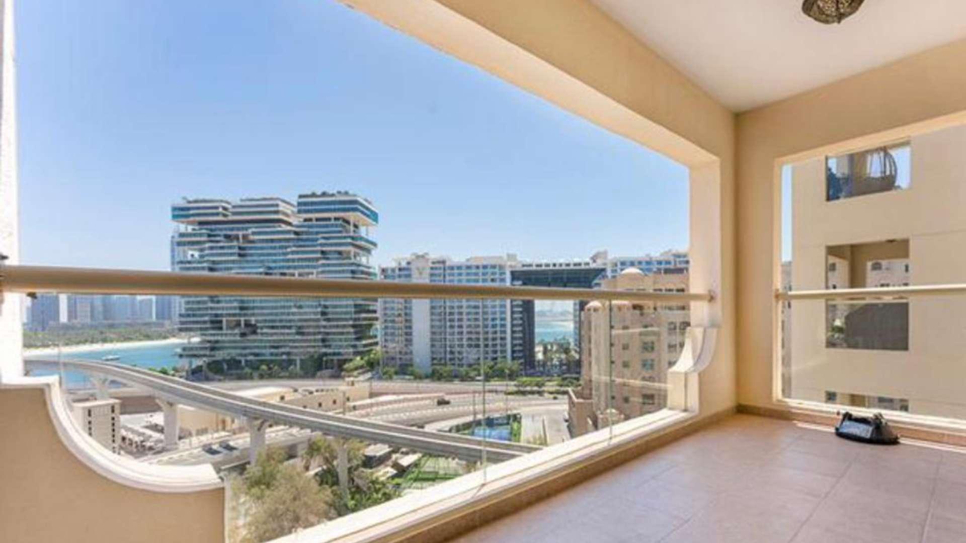 Night view of Shoreline Apartments, Palm Jumeirah with city lights and roads