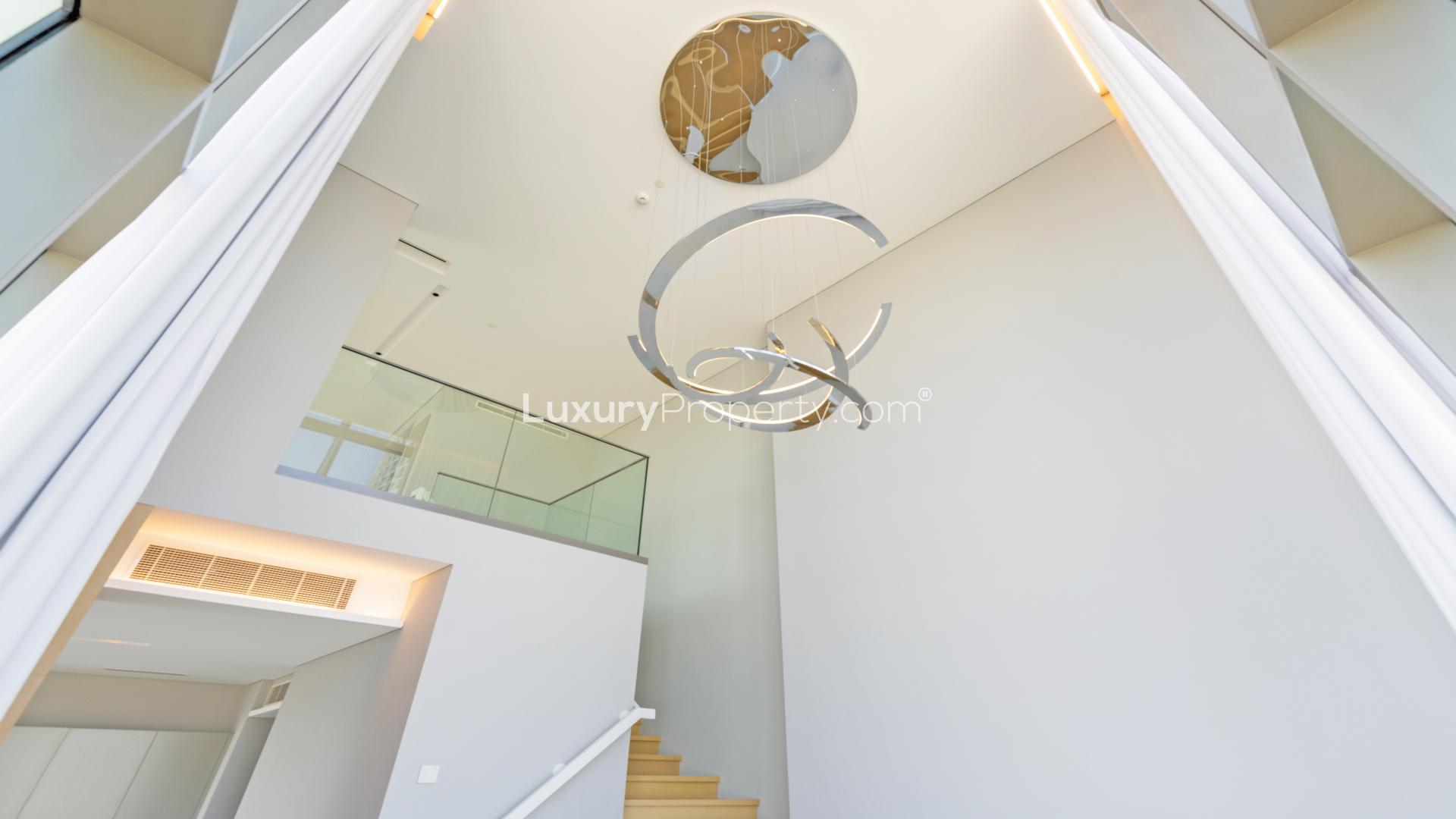 Loft apartment with large windows and modern chandelier in SLS Dubai Hotel & Residences