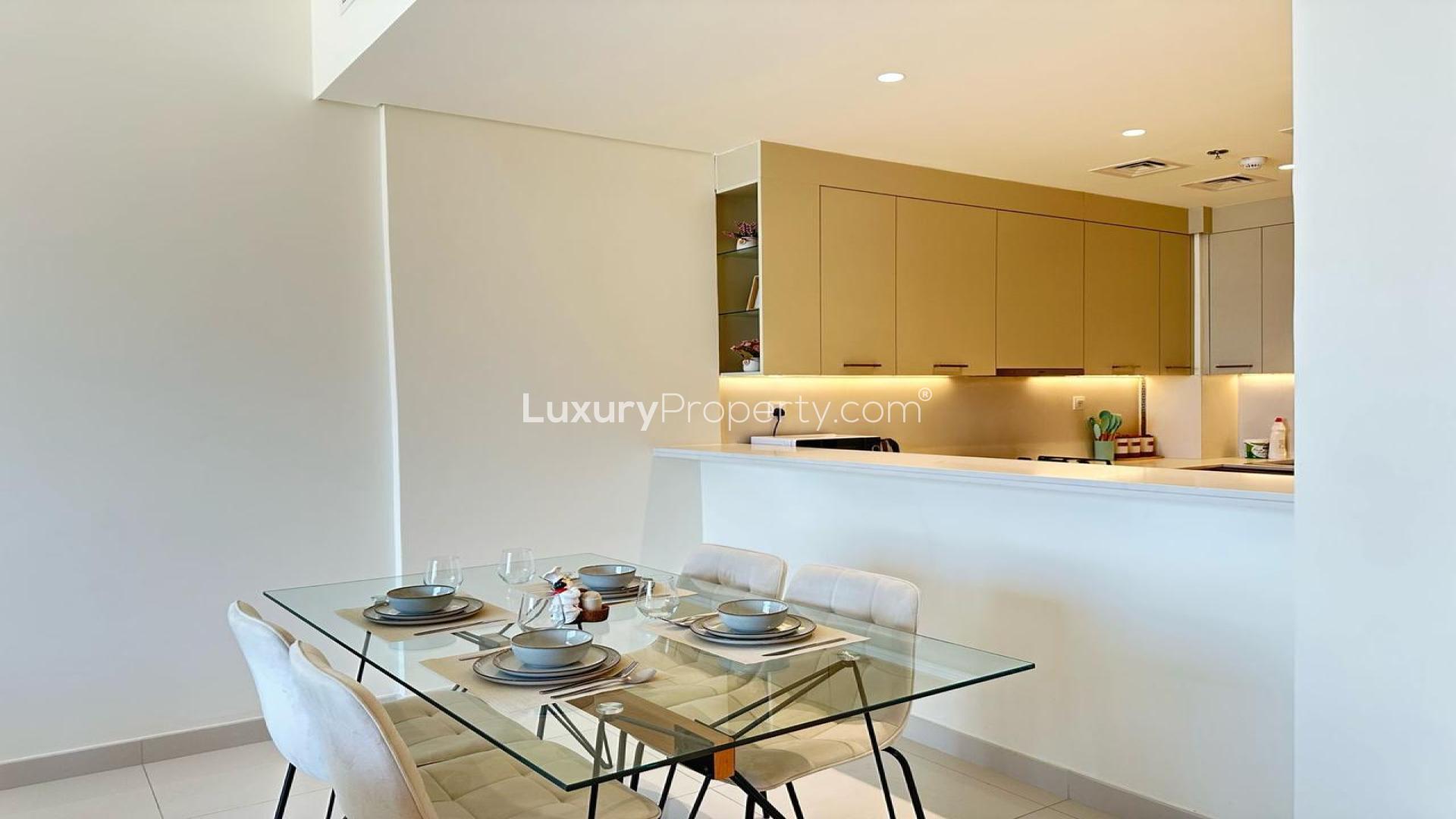 Modern living room in Dubai Silicon Oasis apartment, featuring elegant decor and open kitchen