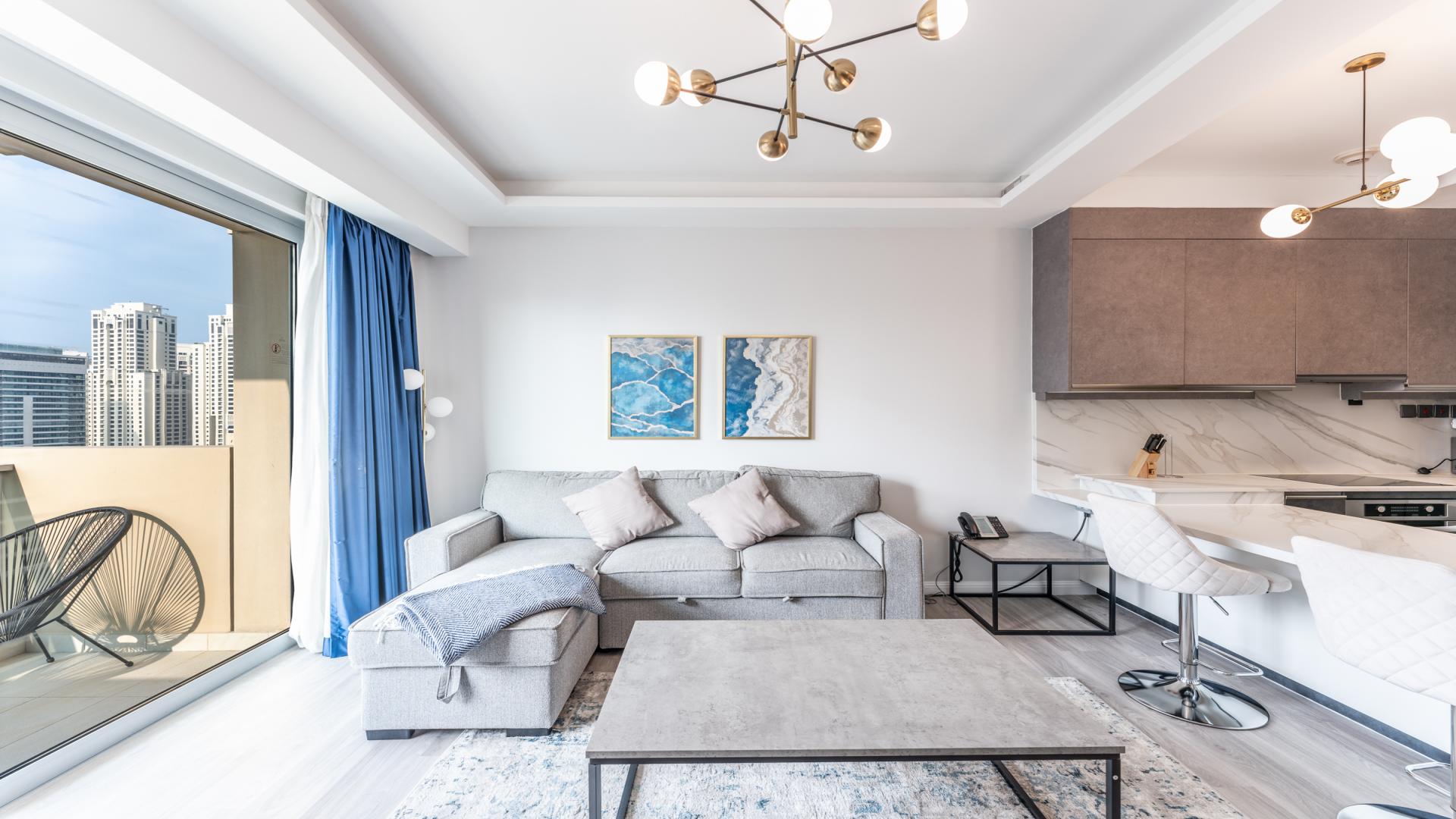 Modern living room with balcony offering stunning marina views in Dubai Marina apartment