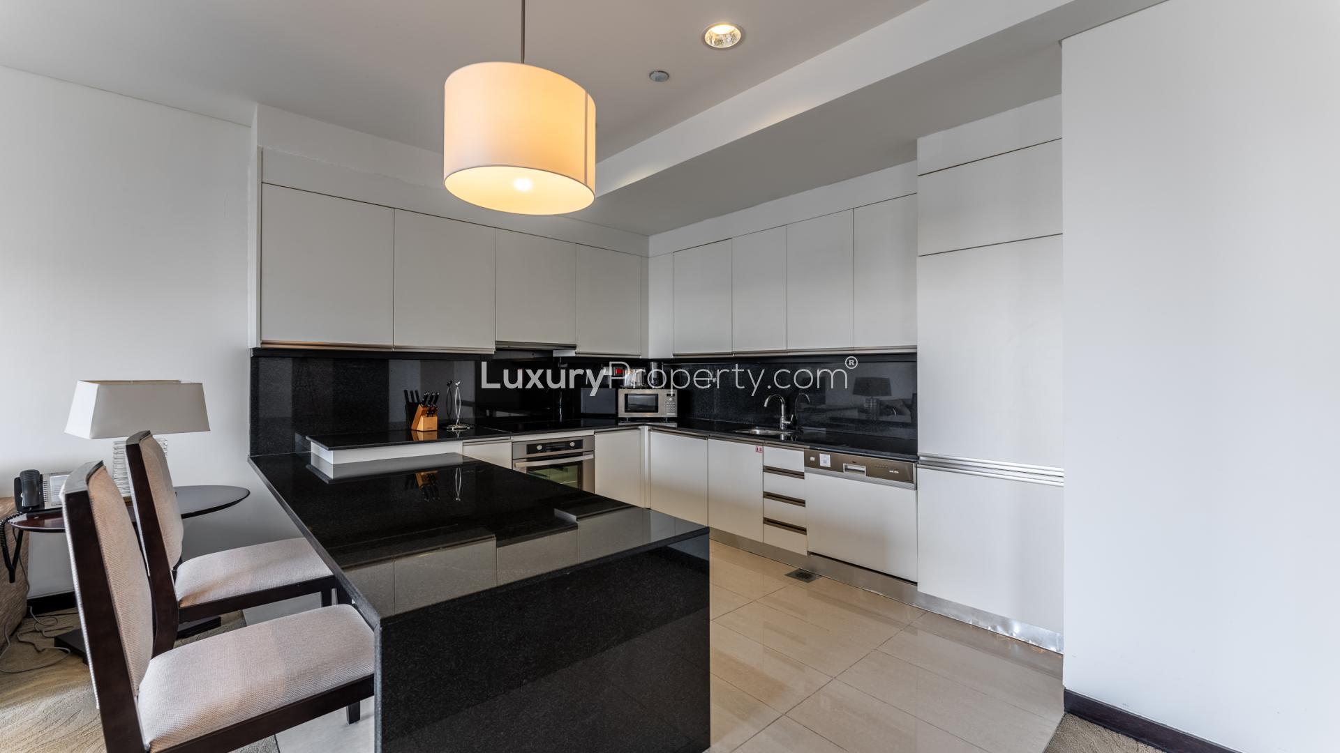 Modern living area in one-bedroom apartment, JW Marriott Dubai Marina, featuring open kitchen design