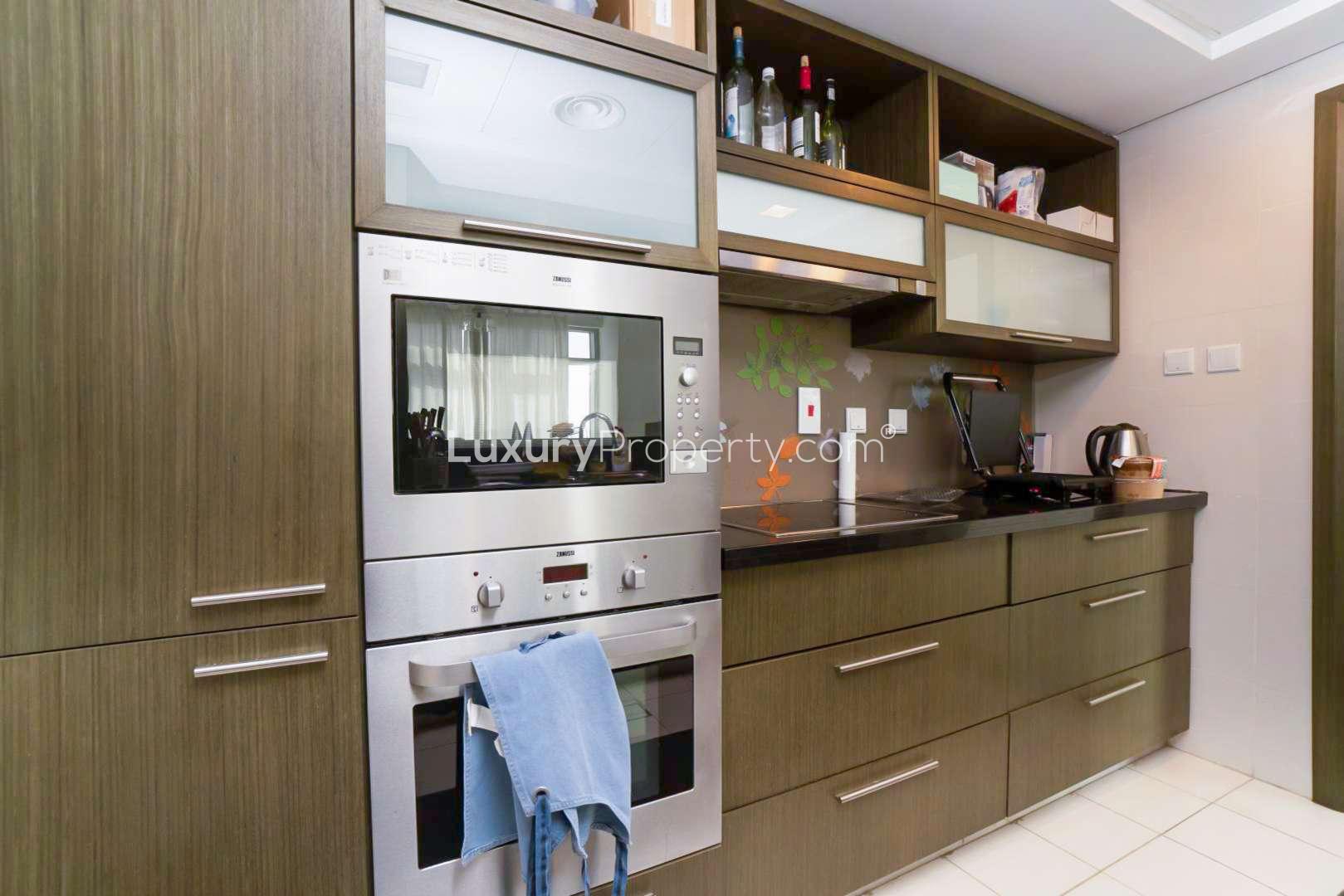 Modern kitchen in one-bedroom apartment, The Lofts, Downtown Dubai, featuring sleek appliances and cabinetry