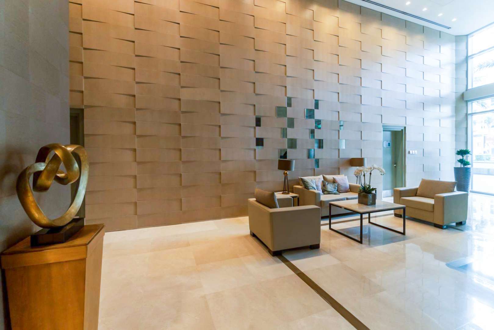 Elegant lobby of The Lofts apartment in Downtown Dubai, featuring modern decor and seating