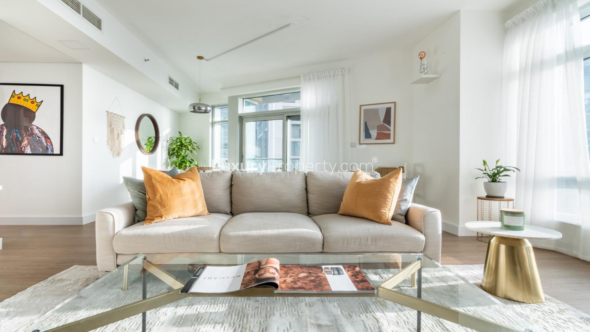 Modern furnished living room in fully upgraded Downtown Dubai apartment with stunning sunset view