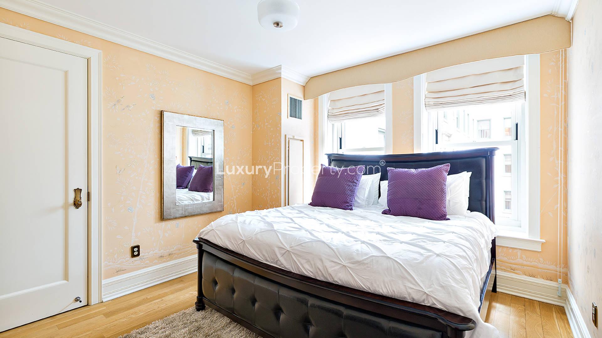 Luxurious Manhattan apartment kitchen with elegant dining area, modern decor, and large wall clock