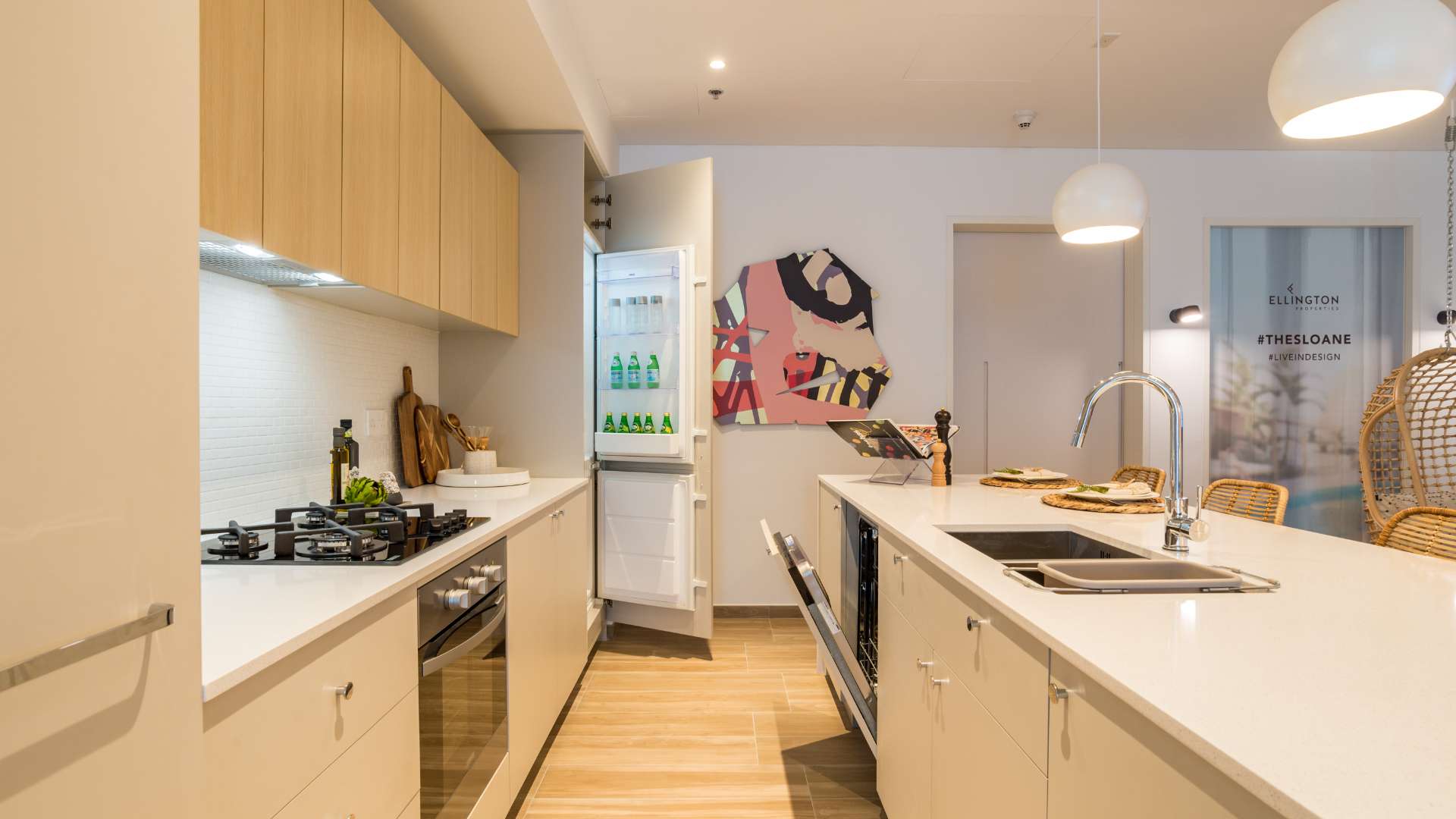 "Modern kitchen in boutique JVC apartment, featuring island seating and stylish decor.",Boutique apartment kitchen in Jumeirah Village Circle, modern design with island and open fridge