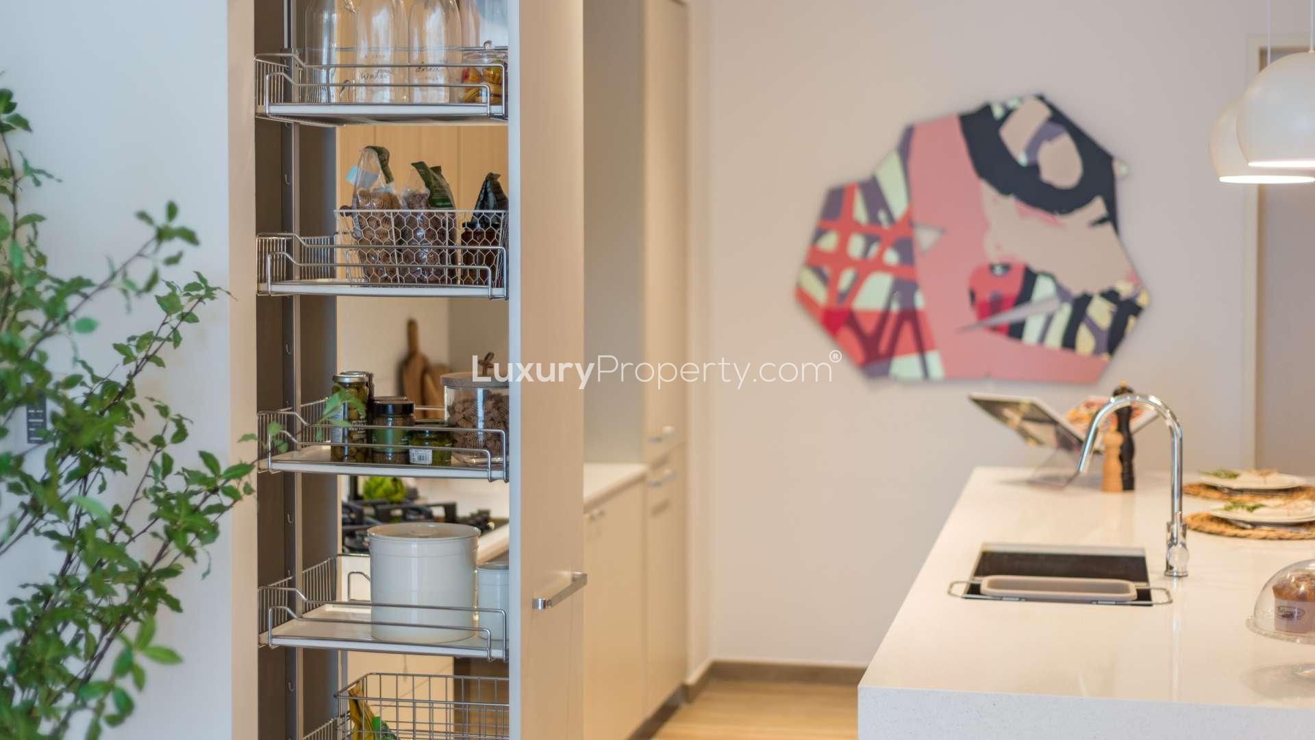 Modern kitchen in Jumeirah Village Circle apartment, featuring sleek countertops and stylish decor