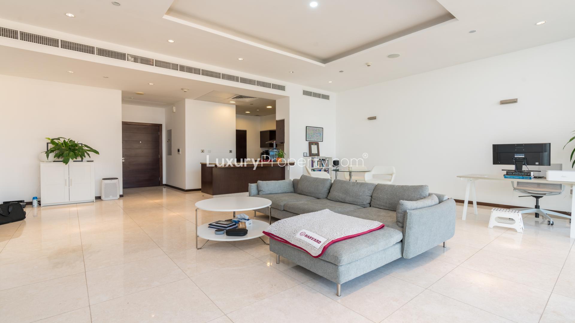 "High-floor apartment balcony view of Tiara Residences, Palm Jumeirah with sea and pool.",Modern living room in Tiara Residences apartment, Palm Jumeirah. Spacious layout and stylish decor